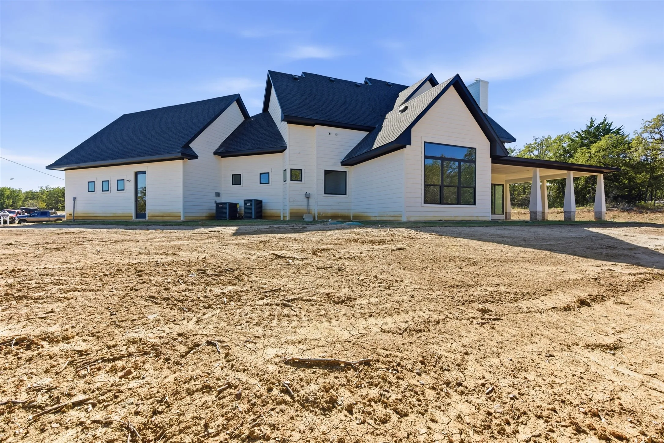 Back of house with a chimney, a patio, and a shingled roof