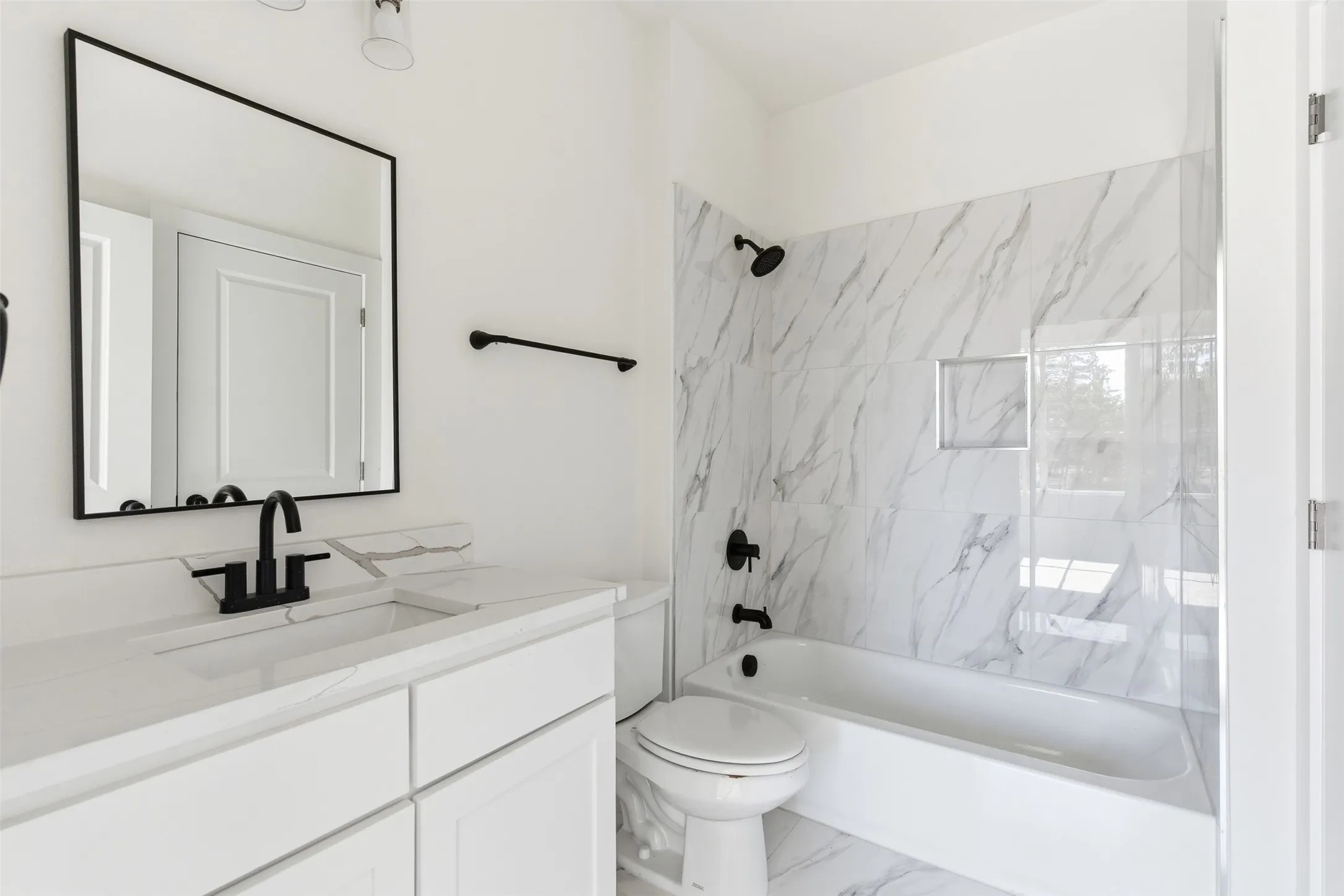Bathroom featuring shower / bathtub combination, vanity, and marble look tiles