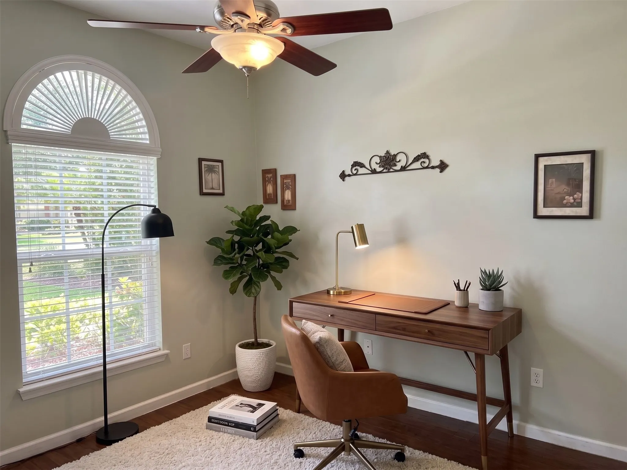 Vaulted ceiling with a ceiling fan, arched transom window, and wood-finish flooring