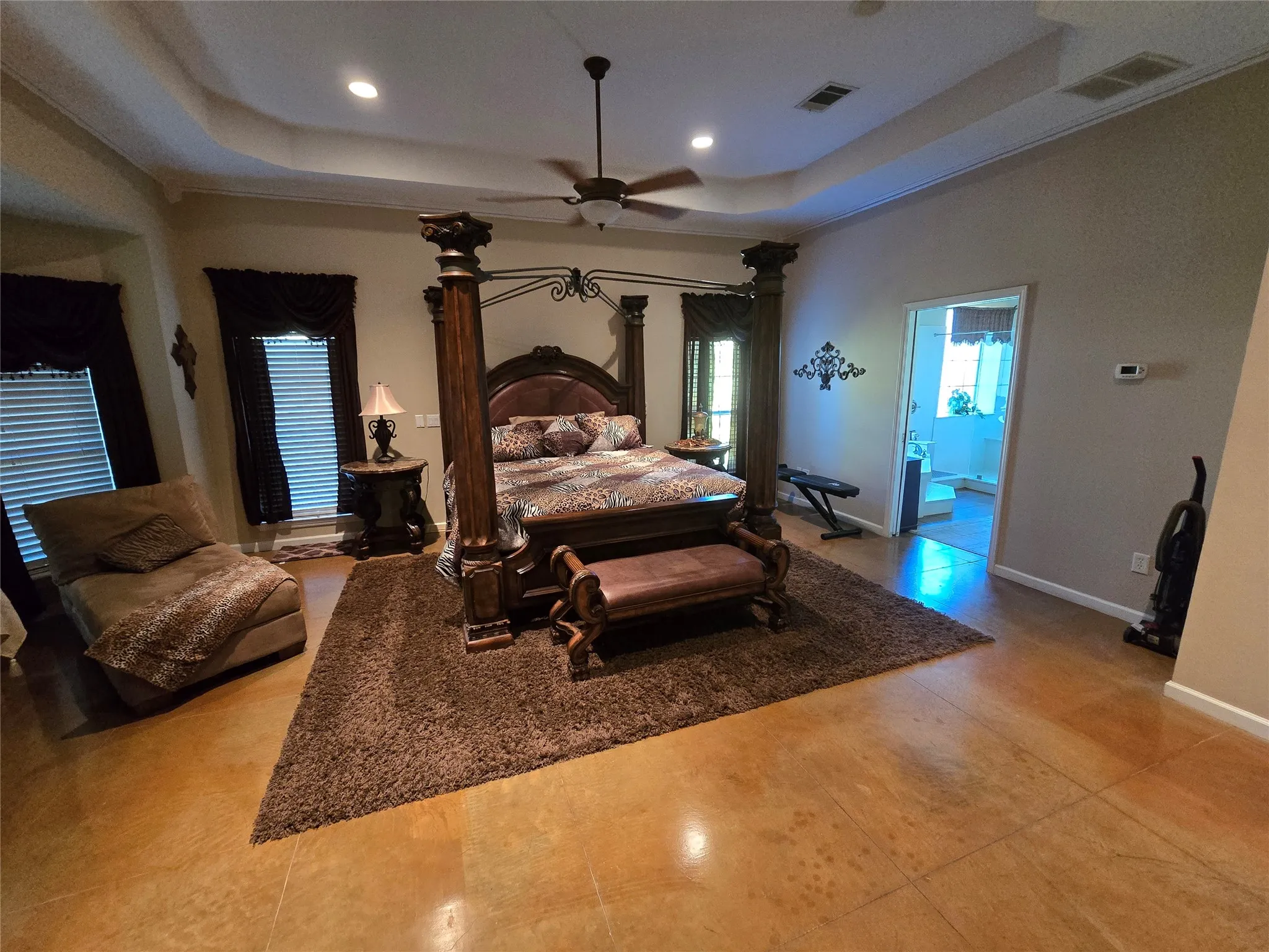 Bedroom featuring a raised ceiling, ceiling fan, and recessed lighting