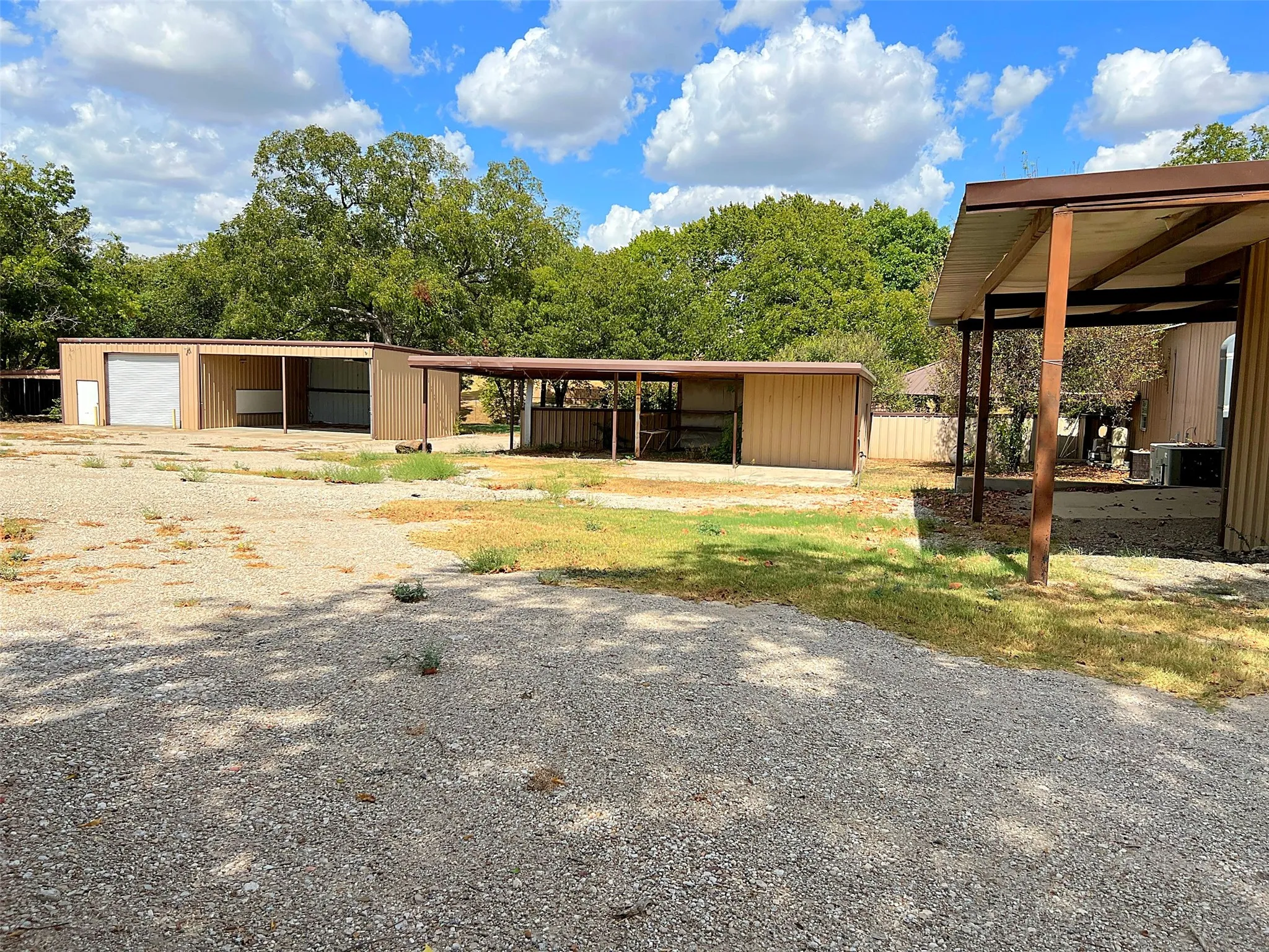 Multiple metal outbuildings with covered parking areas