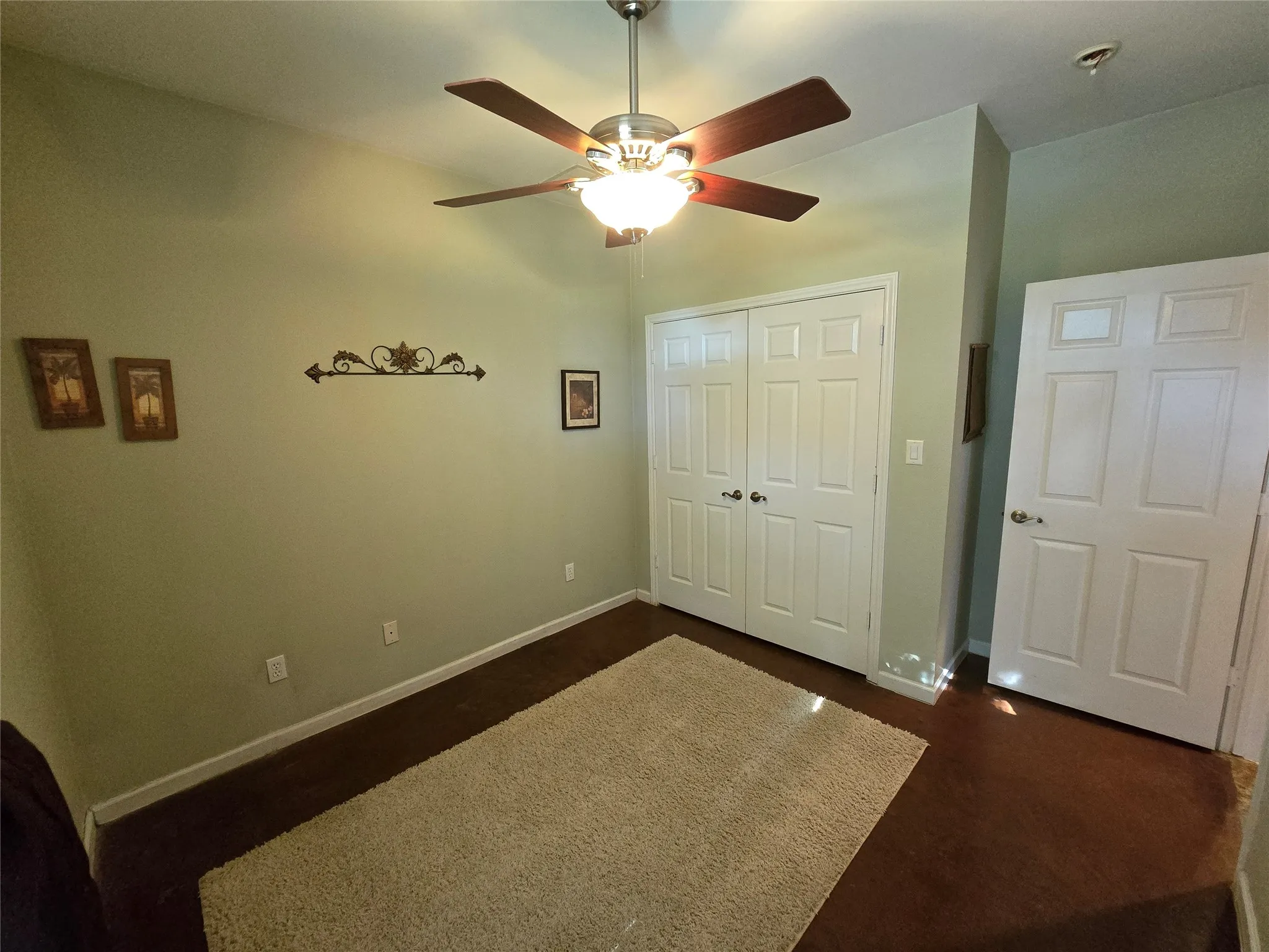 Unfurnished bedroom featuring a closet, ceiling fan, and dark wood finished floors