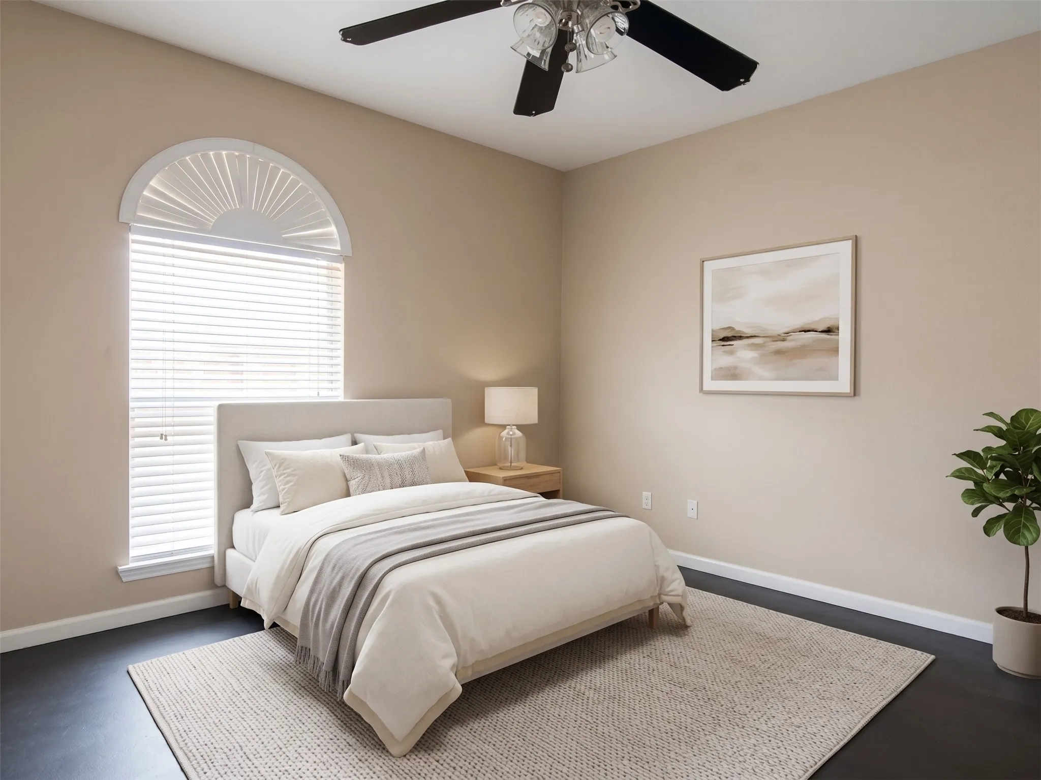 Spacious room featuring a decorative arched window with blinds, dark-toned flooring, and a ceiling fan with integrated lighting