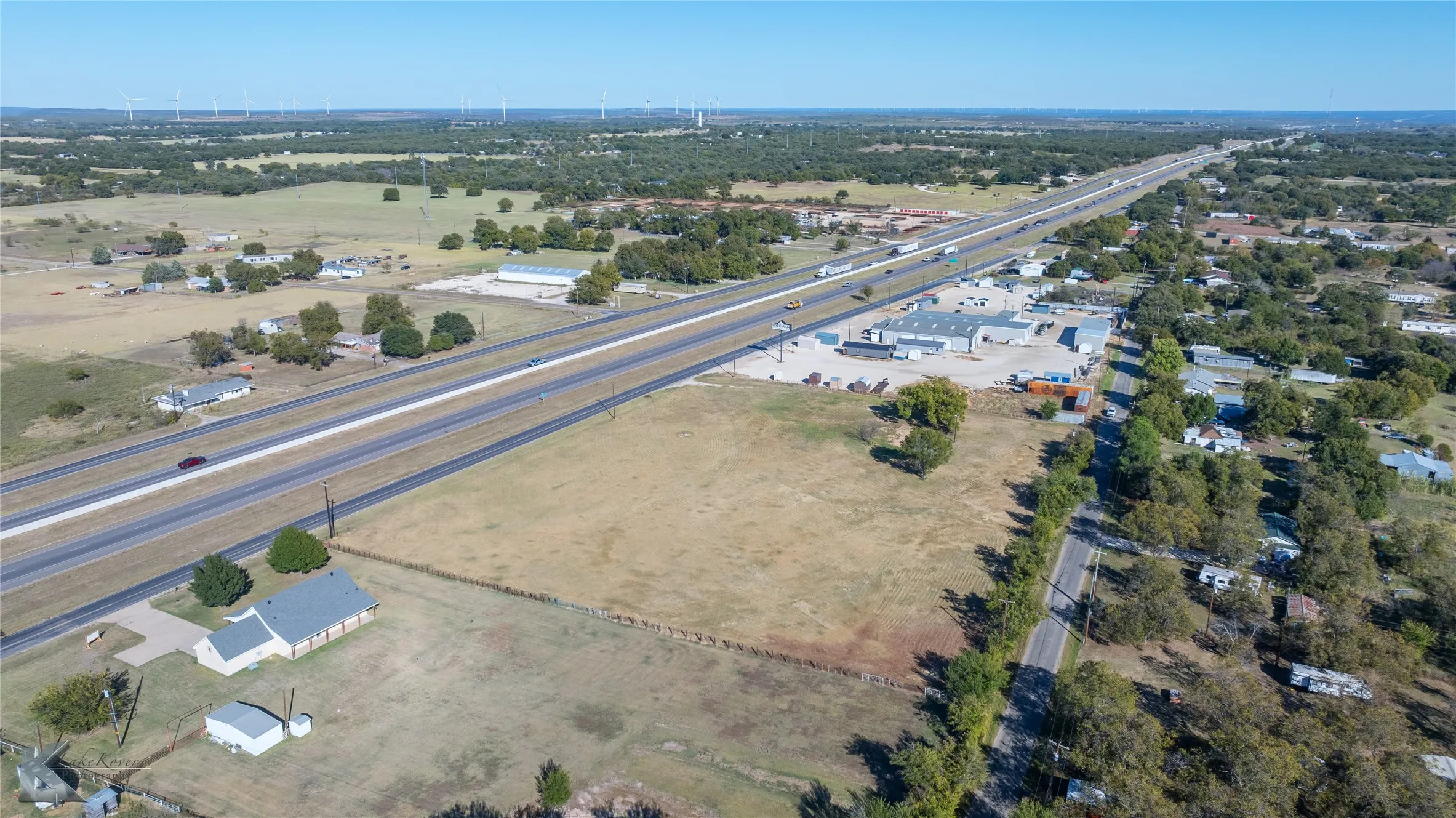 Aerial view of property and surrounding area featuring a tree filled landscape