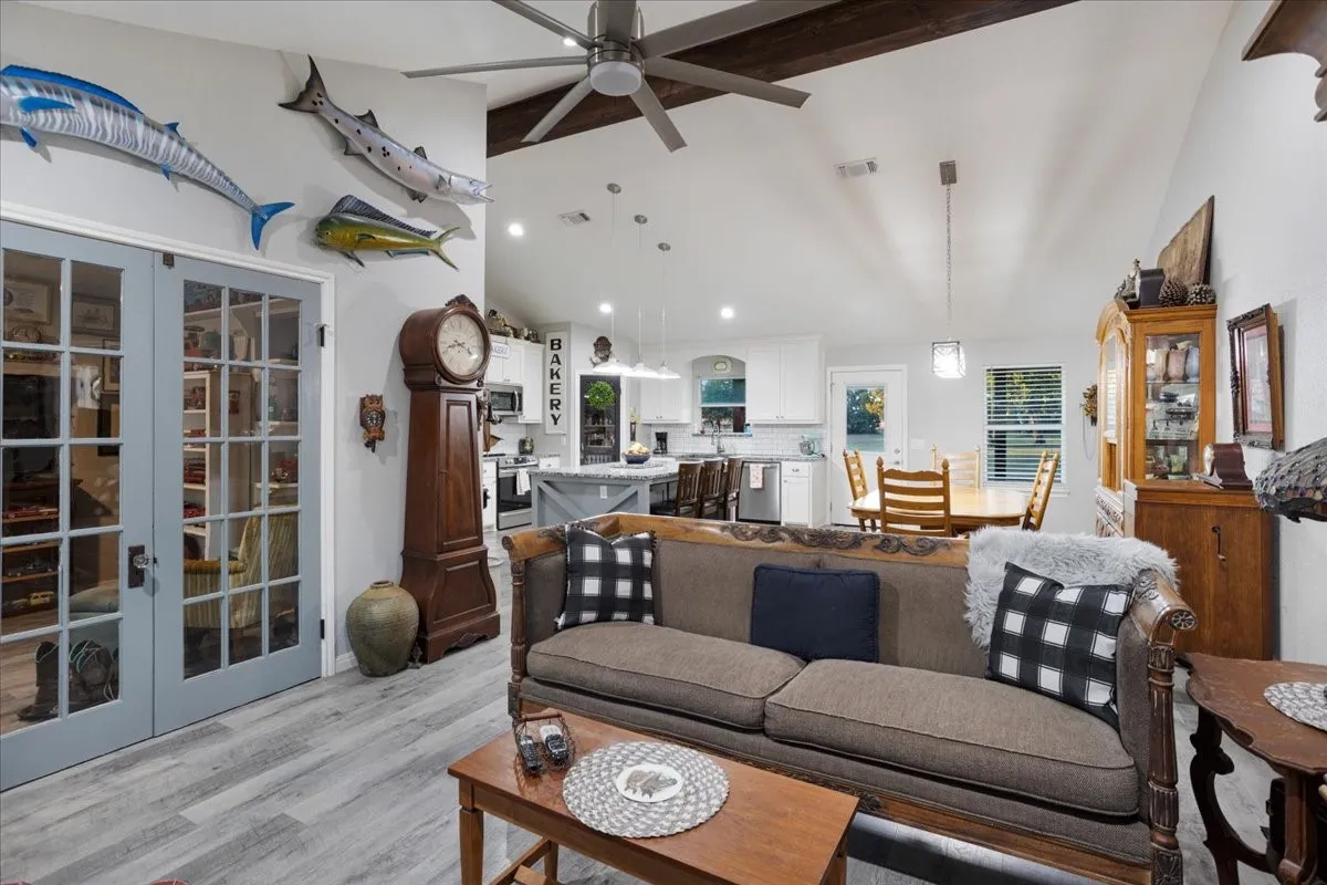 Living area featuring beam ceiling, light wood-style floors, a ceiling fan, high vaulted ceiling, and recessed lighting