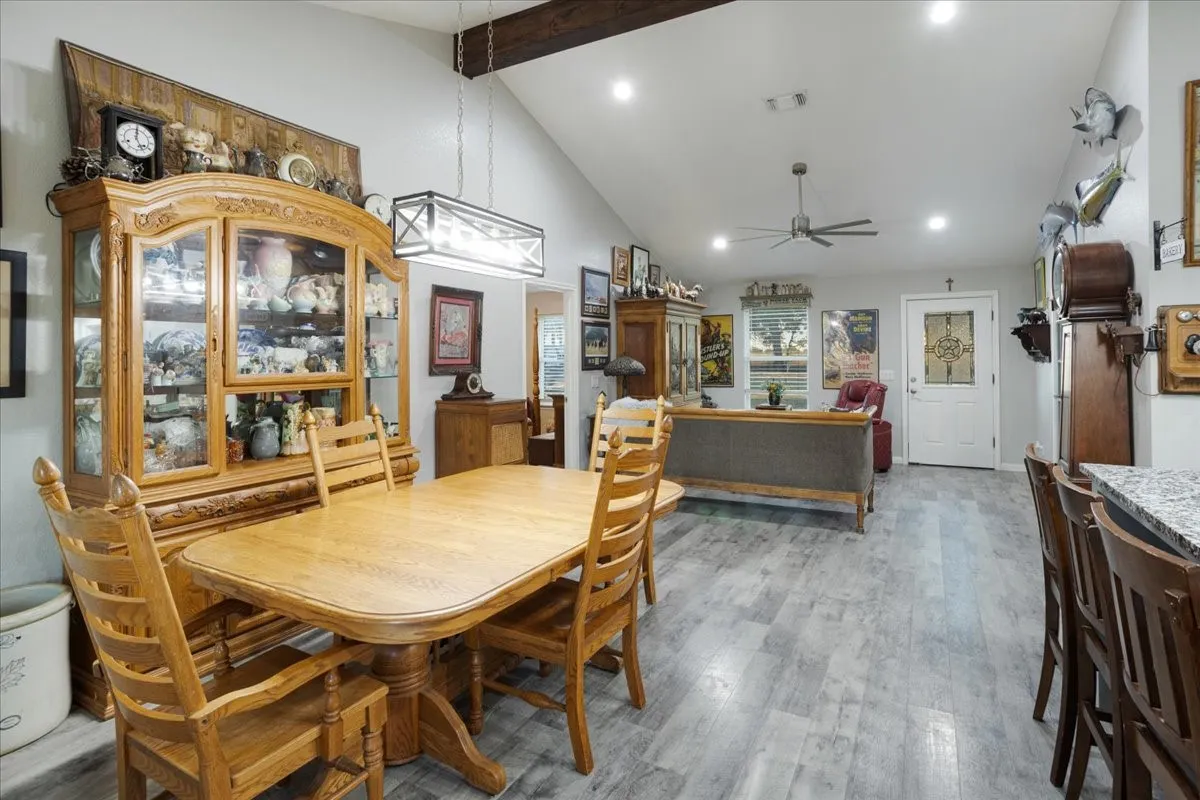 Dining space with beamed ceiling, a ceiling fan, wood finished floors, recessed lighting, and high vaulted ceiling