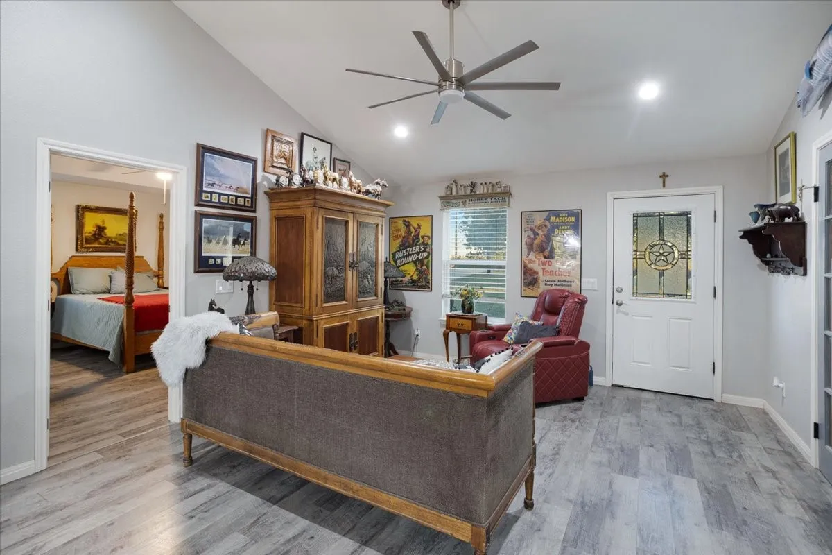 Living room featuring light wood-style floors, a ceiling fan, recessed lighting, and high vaulted ceiling
