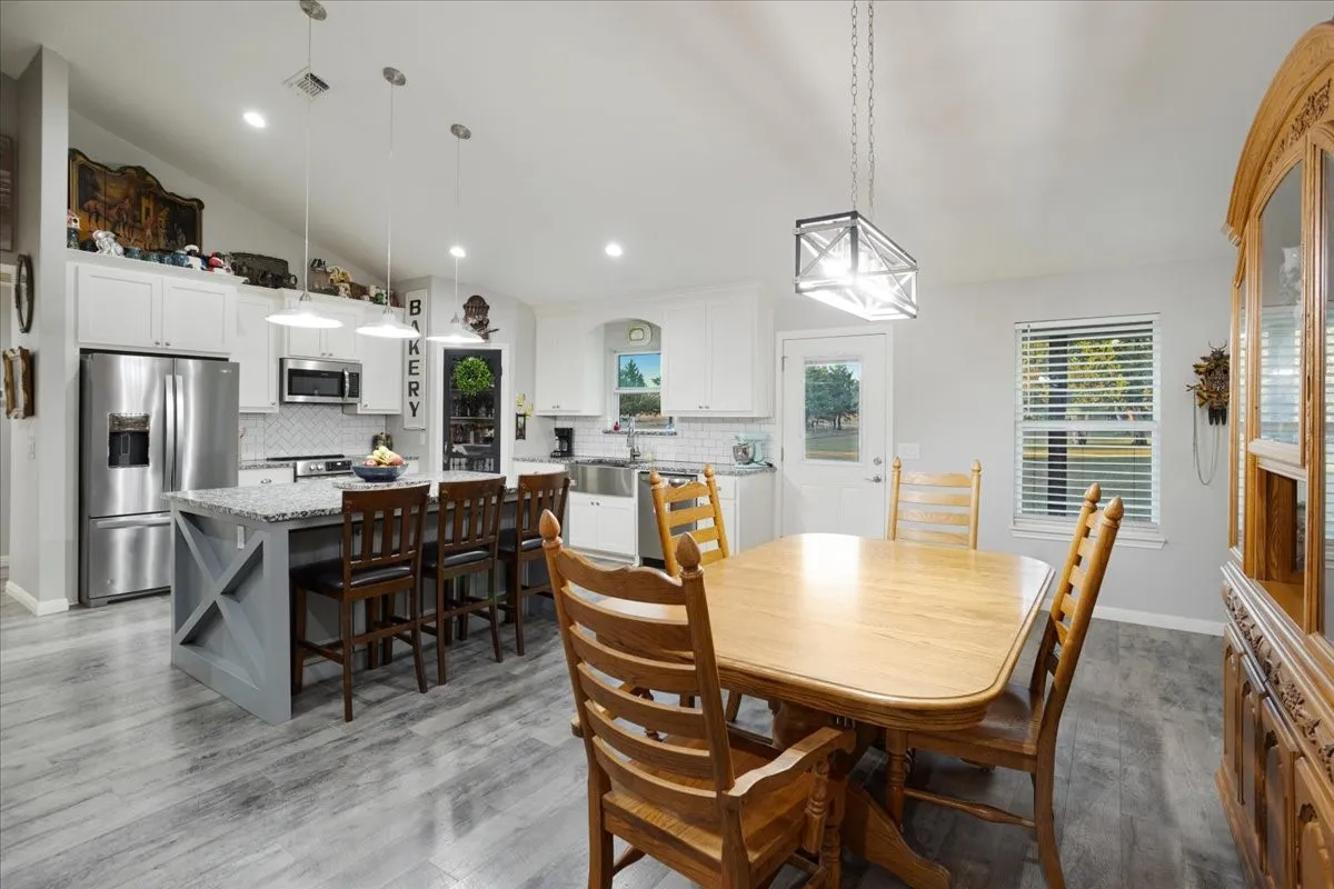 Dining room featuring lofted ceiling, light wood-style floors, and recessed lighting