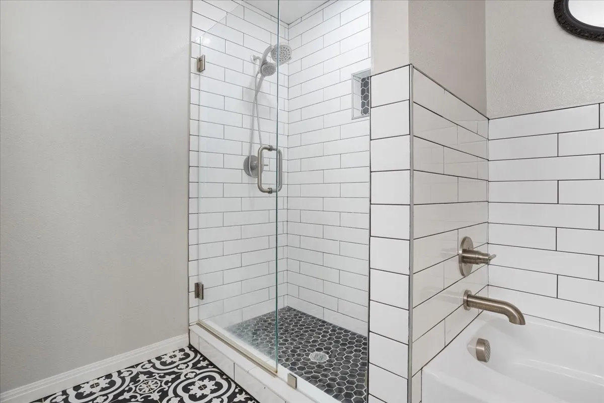 Bathroom with a stall shower, a bath, and tile patterned flooring