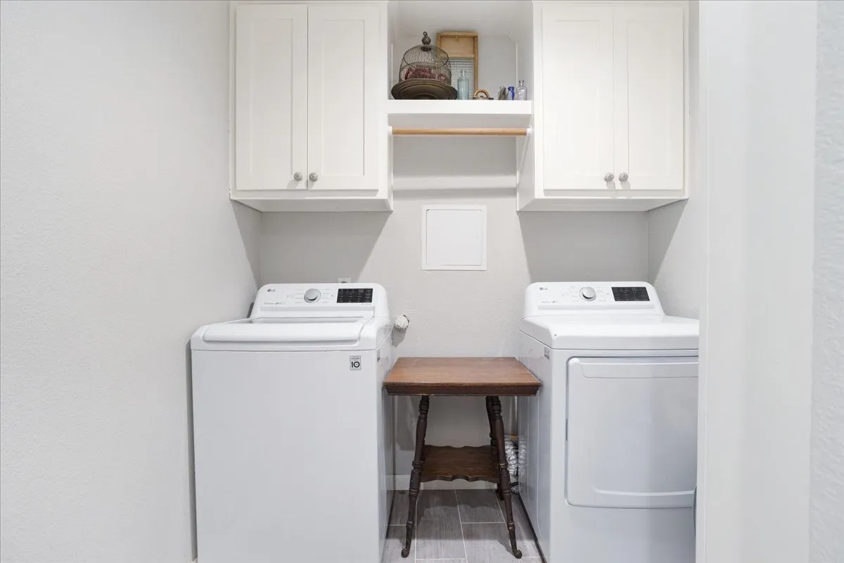 Laundry room featuring separate washer and dryer and cabinet space