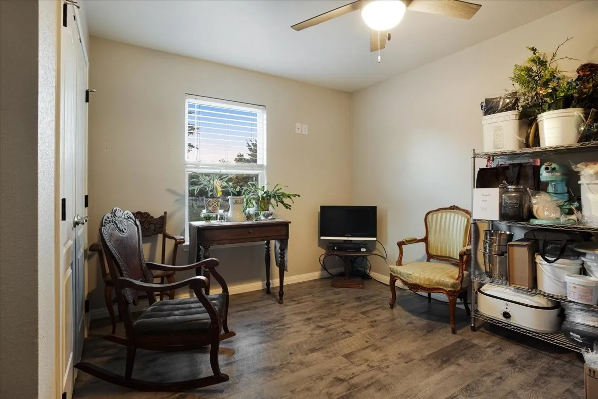 Sitting room featuring dark wood finished floors and a ceiling fan