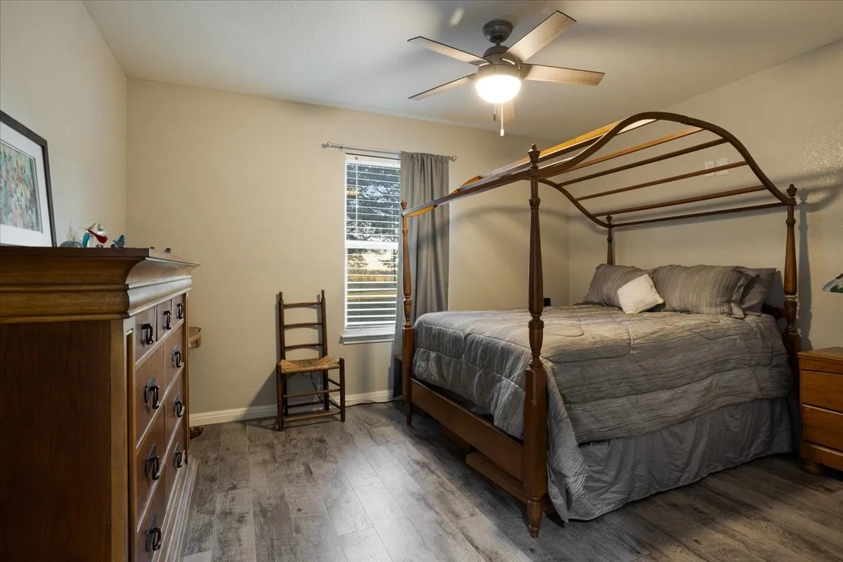 Bedroom with dark wood-type flooring and a ceiling fan
