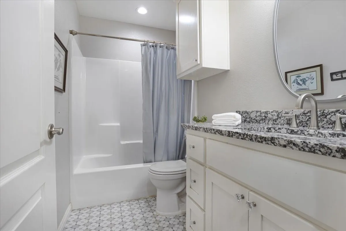 Full bath with vanity and shower / bath combination with curtain