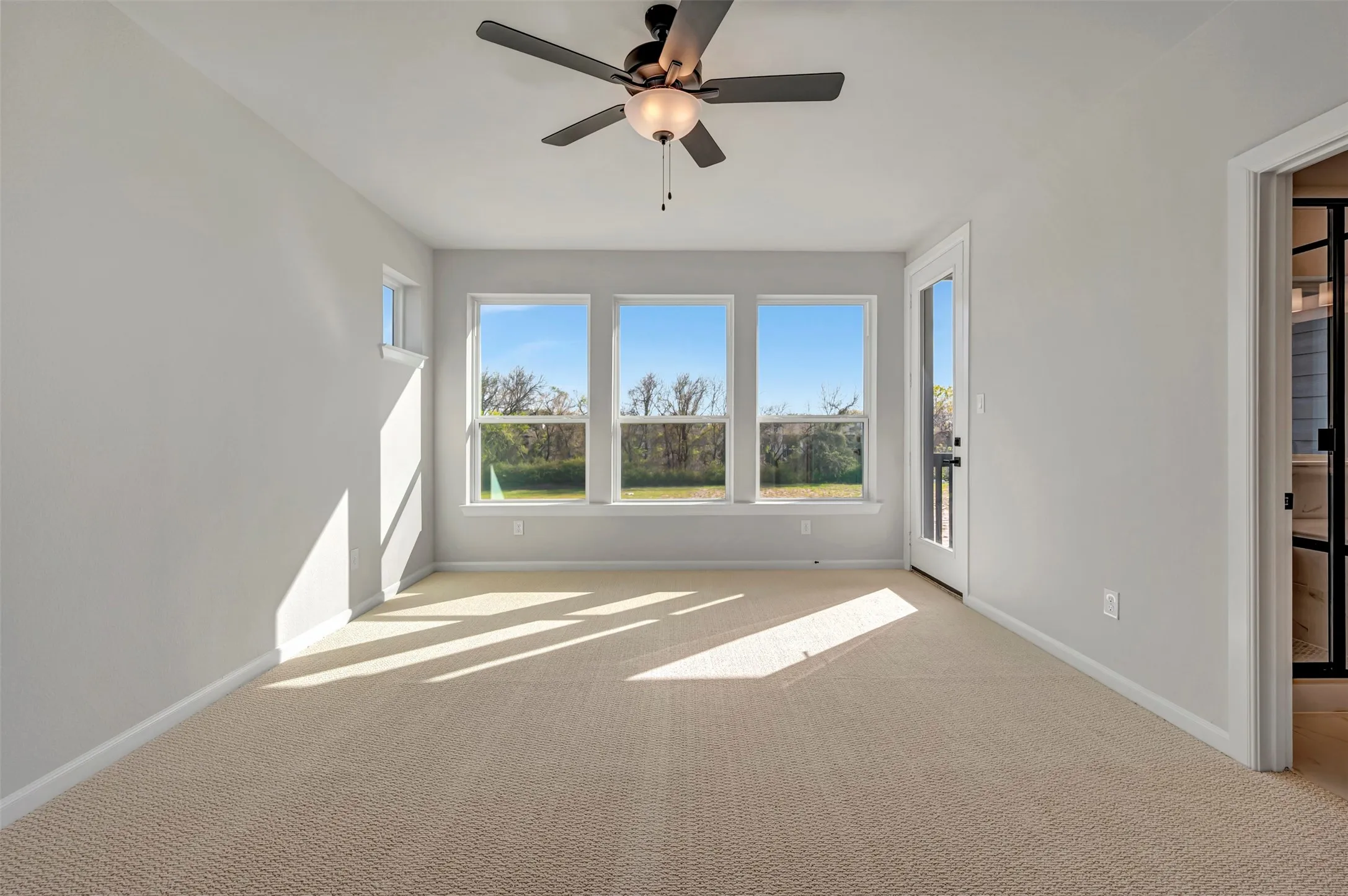 Spare room with a ceiling fan and light carpet