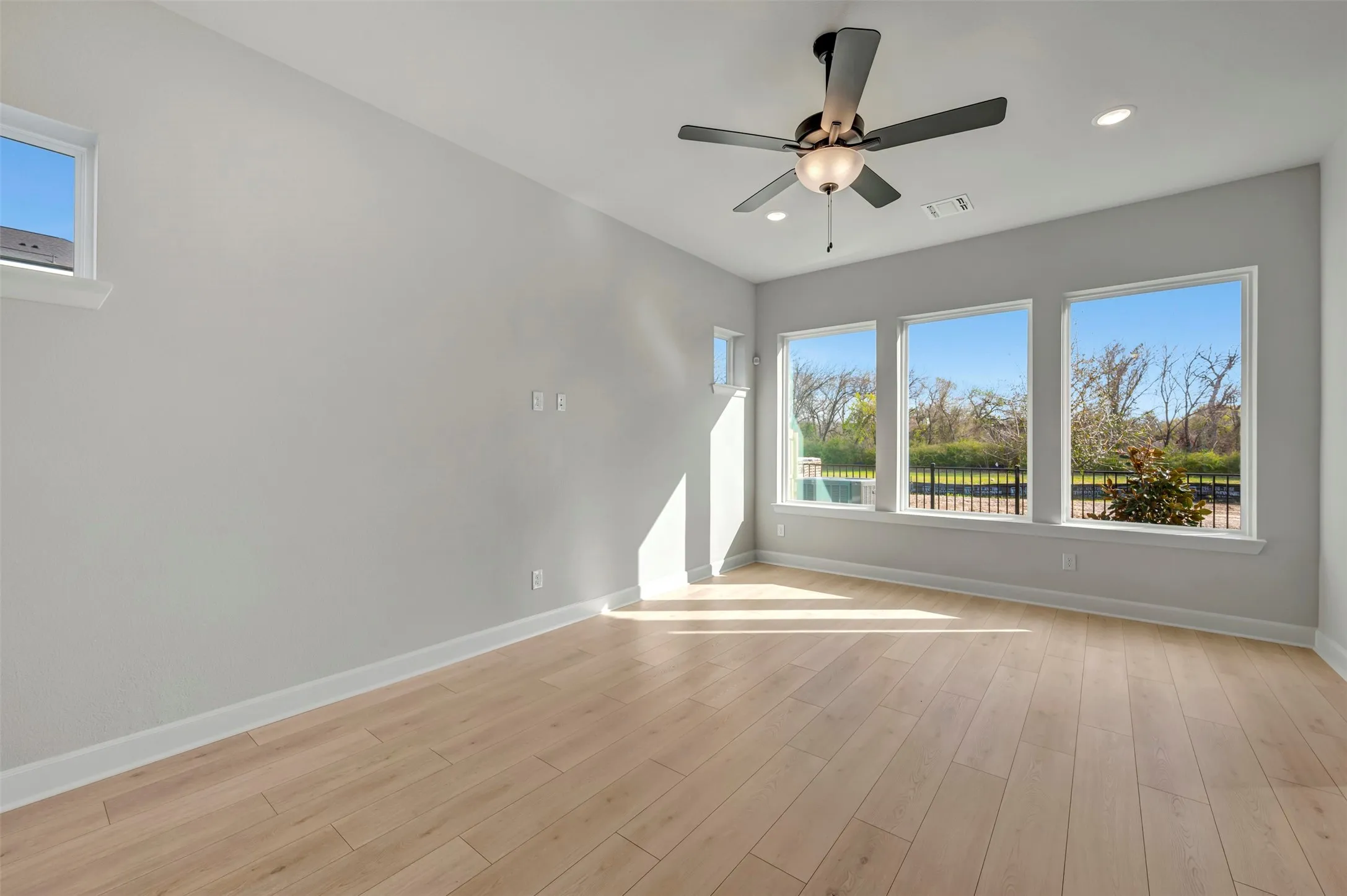 Unfurnished room with ceiling fan, light wood-style flooring, and recessed lighting