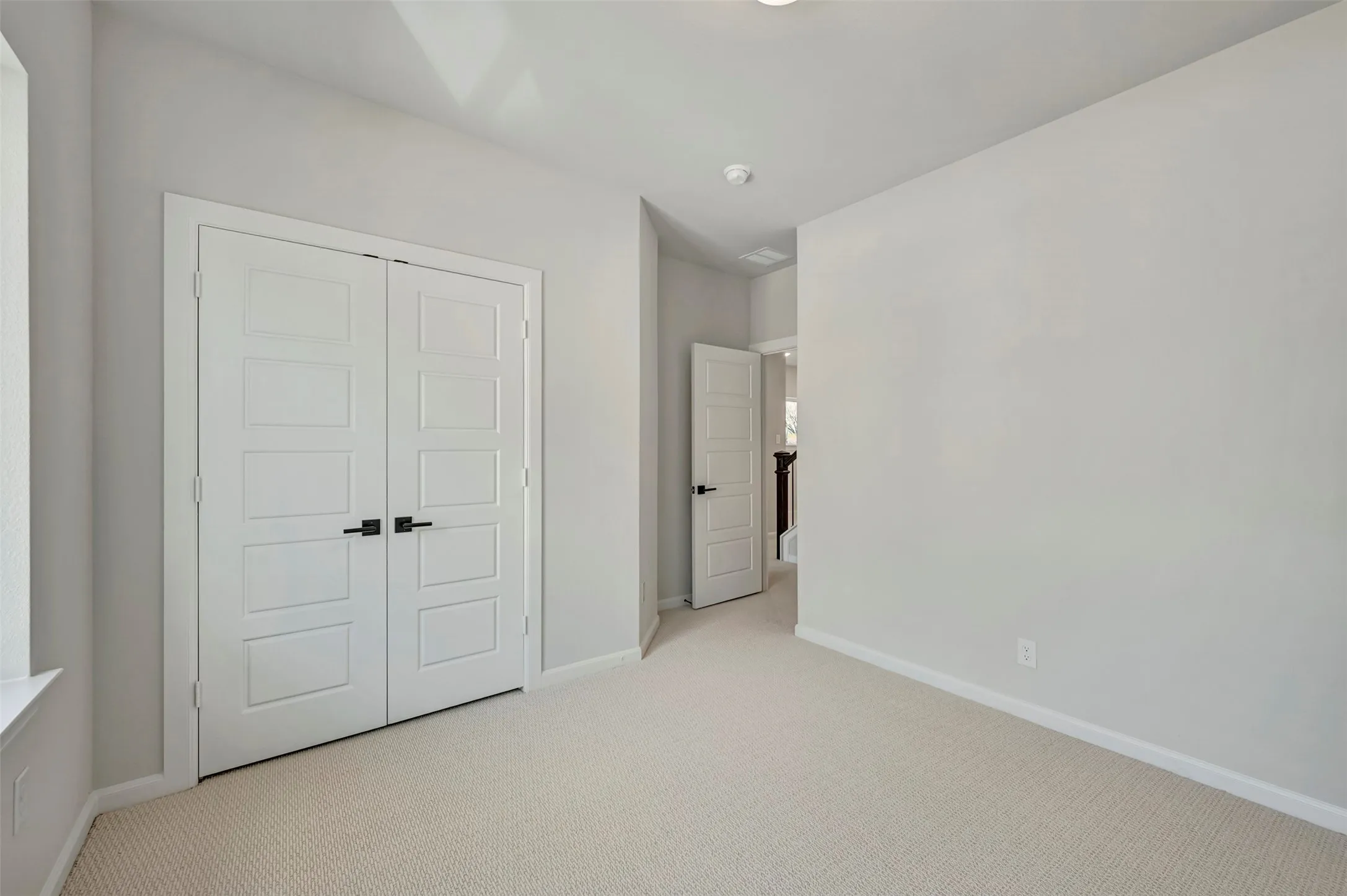 Unfurnished bedroom with light carpet and a closet
