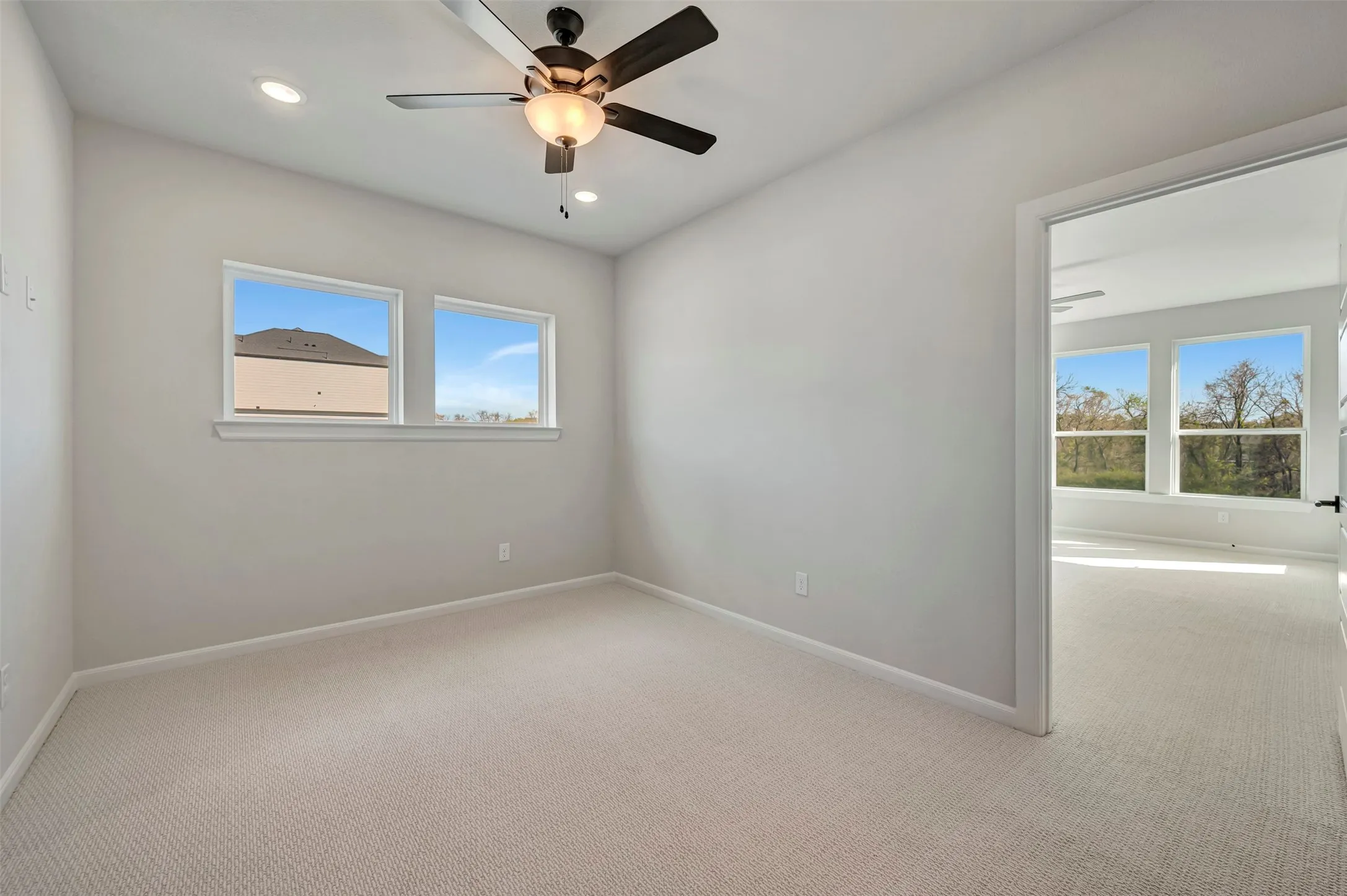 Empty room featuring light colored carpet, recessed lighting, and a ceiling fan