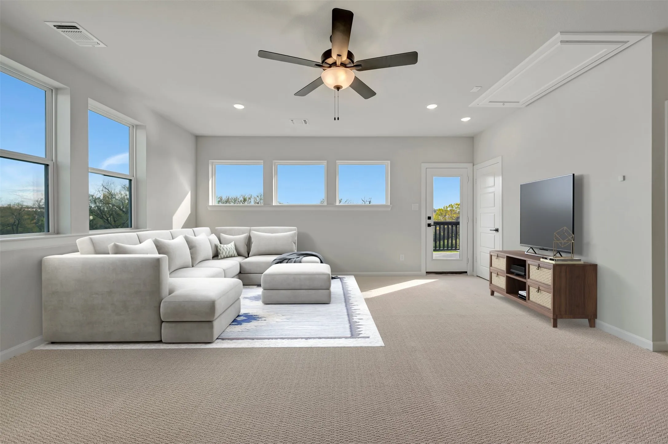 Living area with a ceiling fan, recessed lighting, and light colored carpet