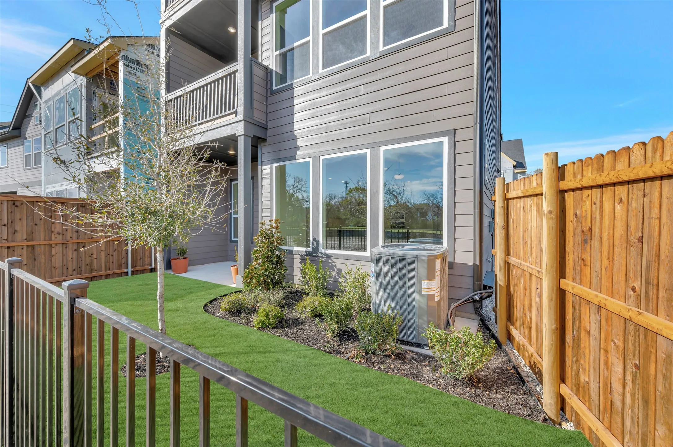 Back of house featuring a balcony and a fenced backyard
