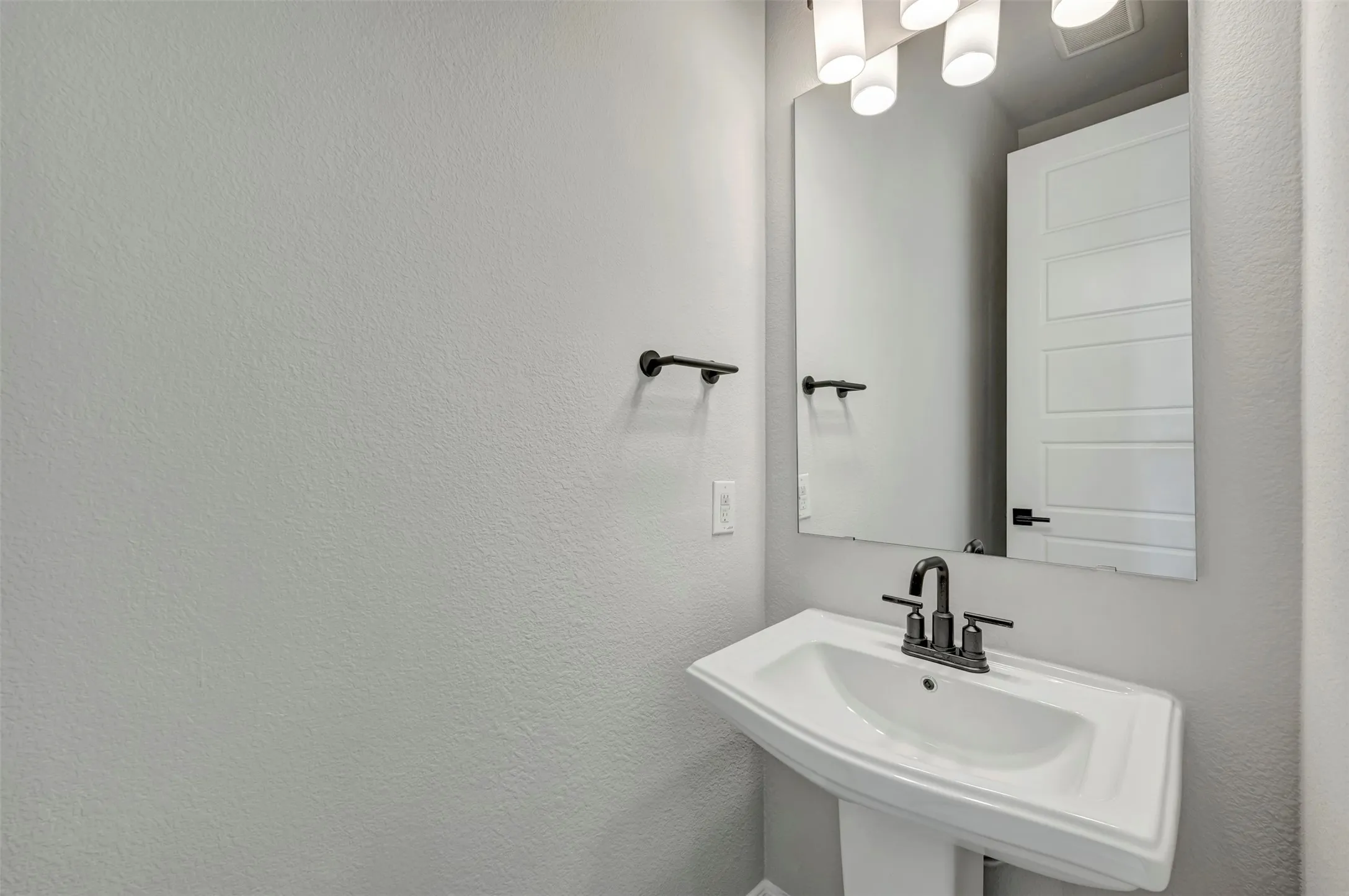 Bathroom featuring a sink and a textured wall