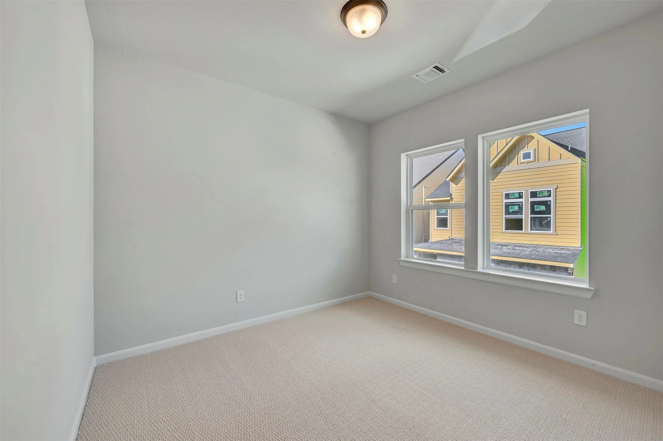 Empty room with light carpet and baseboards