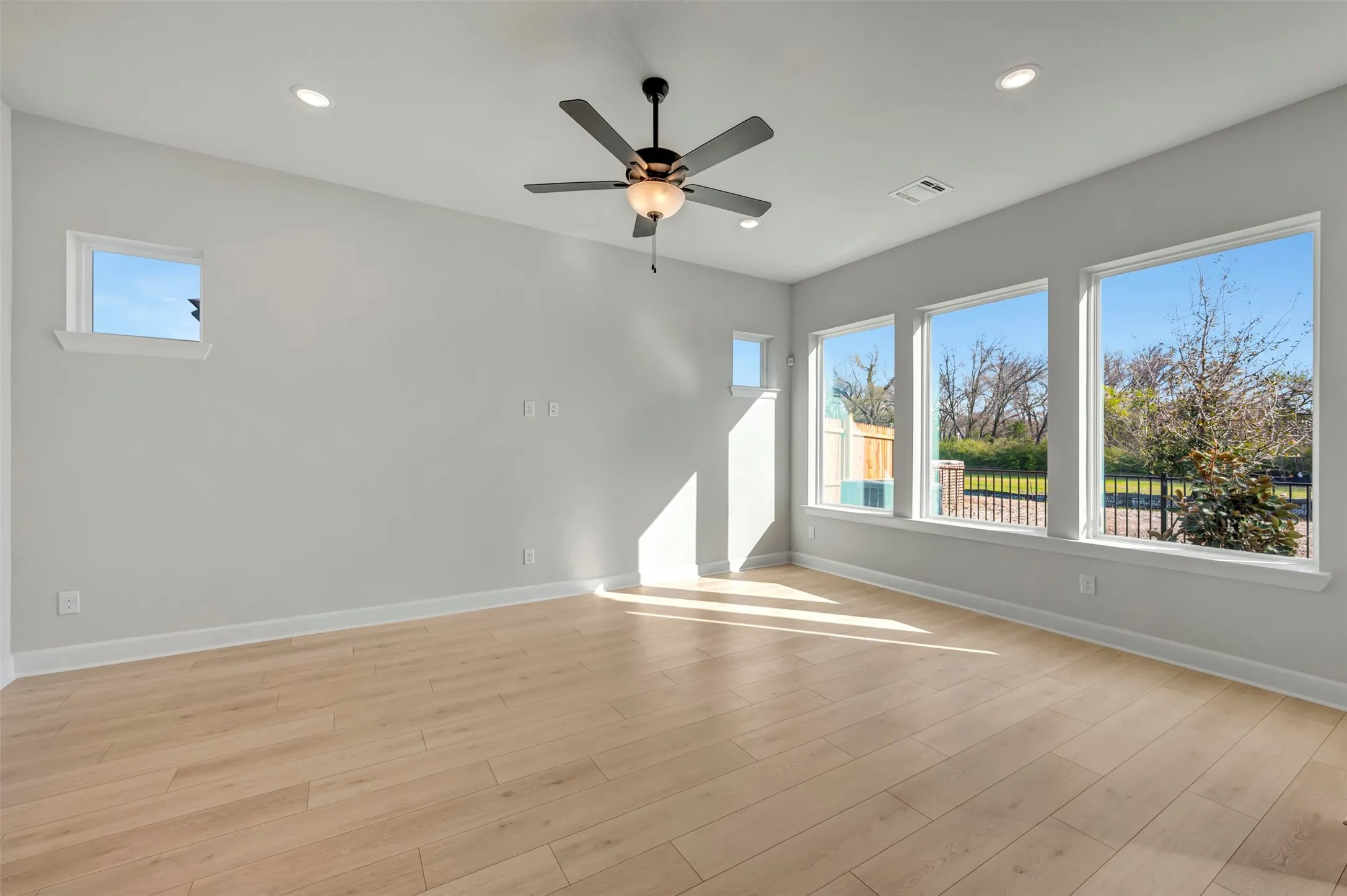 Unfurnished room featuring light wood-style flooring, ceiling fan, and recessed lighting