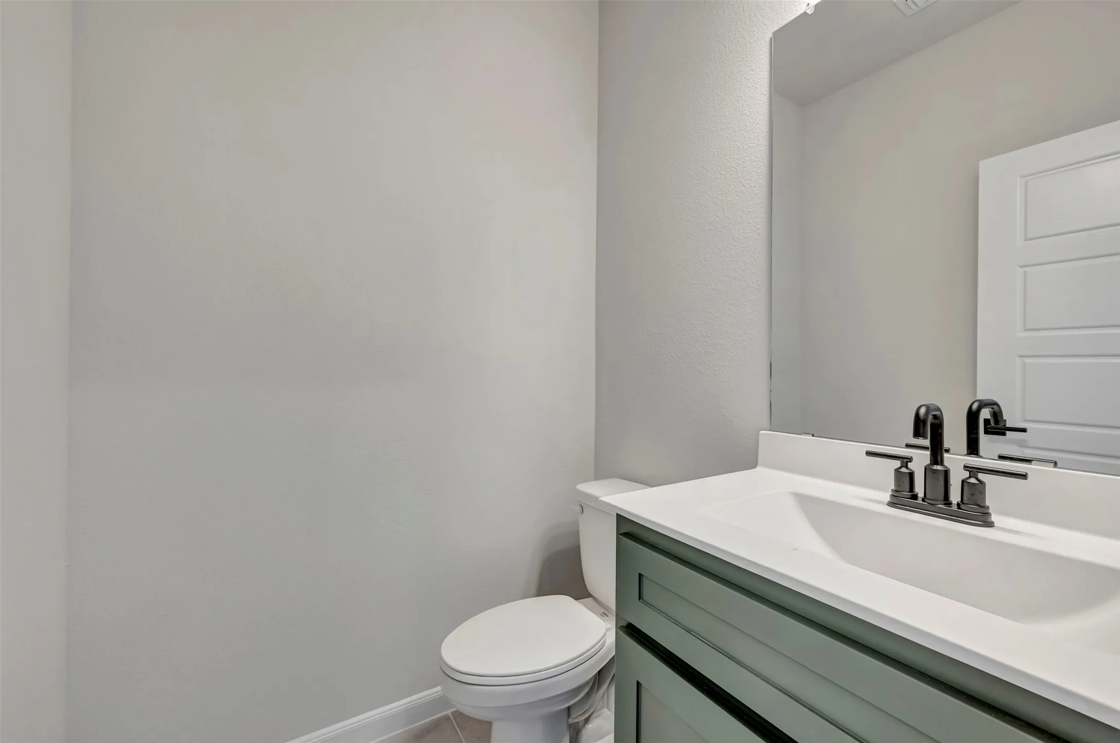 Half bathroom featuring vanity and toilet