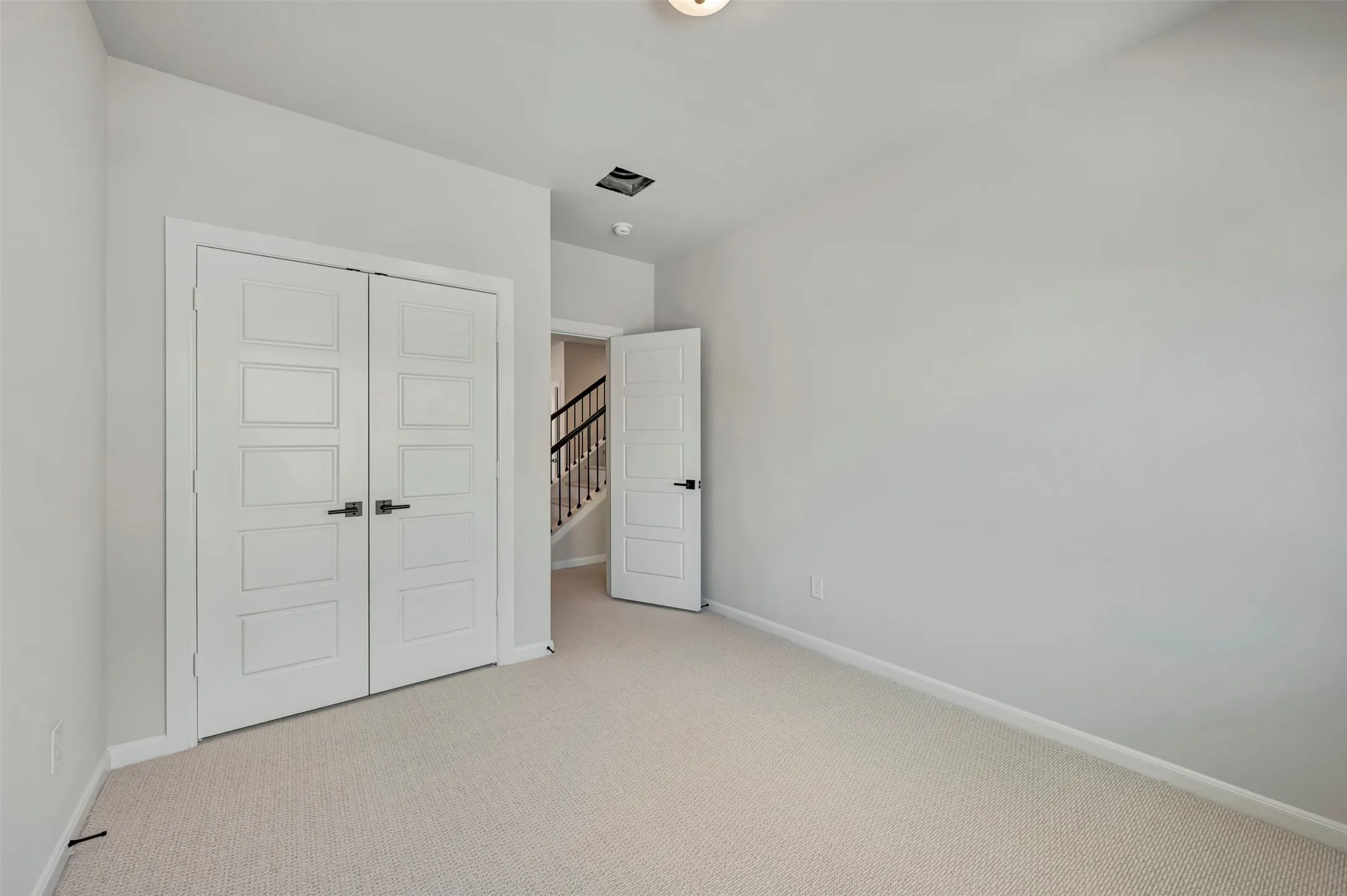 Unfurnished bedroom with light colored carpet and a closet