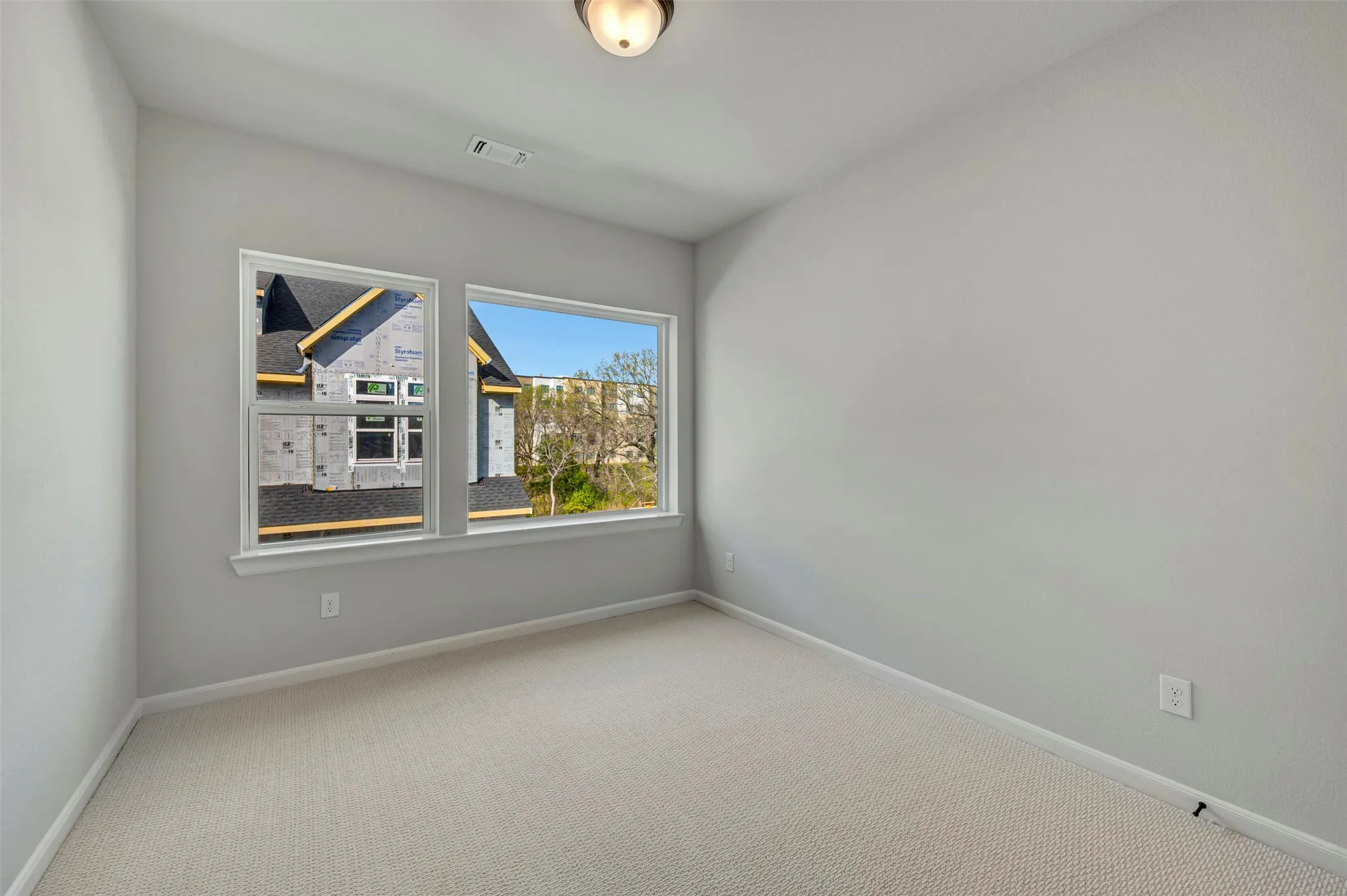 Empty room with light carpet and baseboards