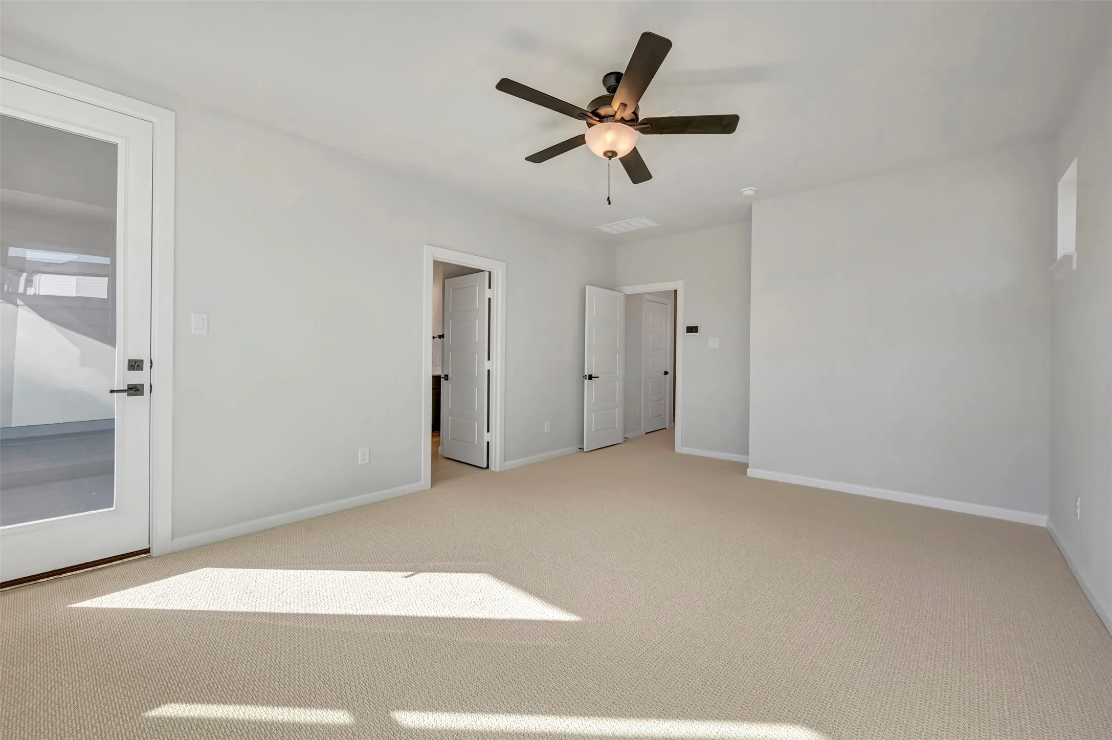 Unfurnished bedroom with light carpet and ceiling fan