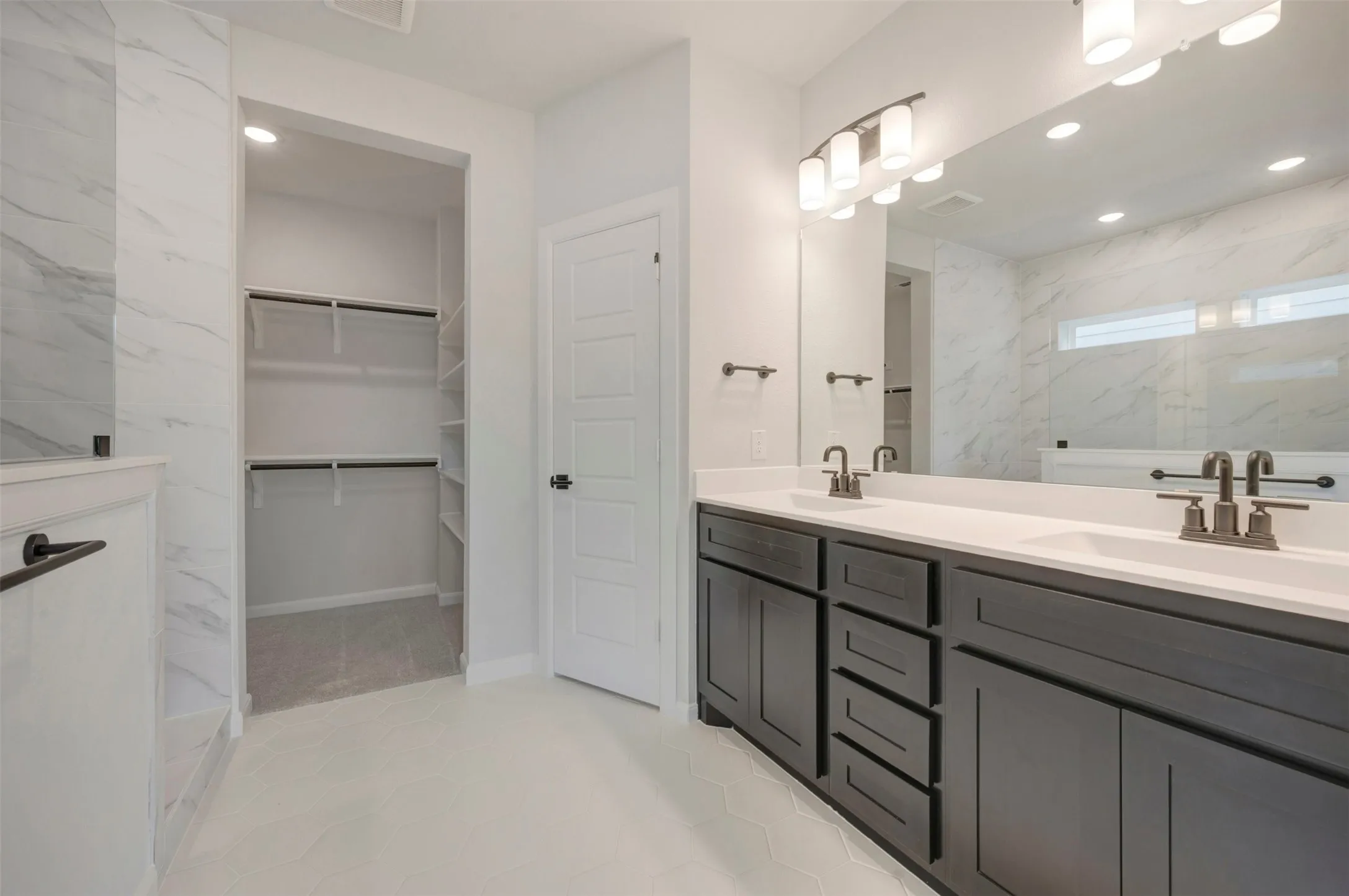 Bathroom featuring a double vanity with dark wood-finish cabinetry and white countertops