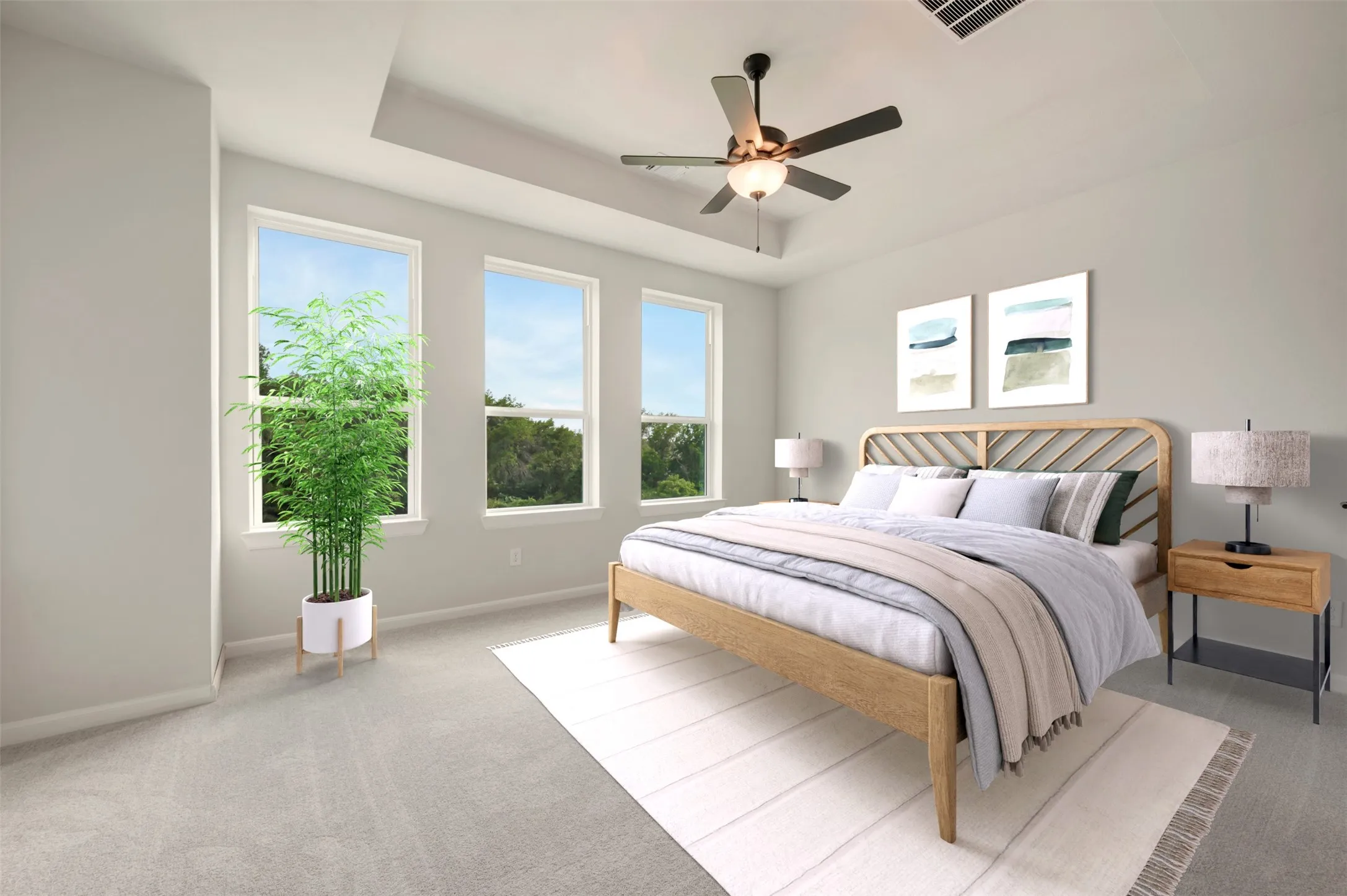Bedroom featuring a tray ceiling with a ceiling fan, three large windows, light gray wall paint, and light gray carpet
