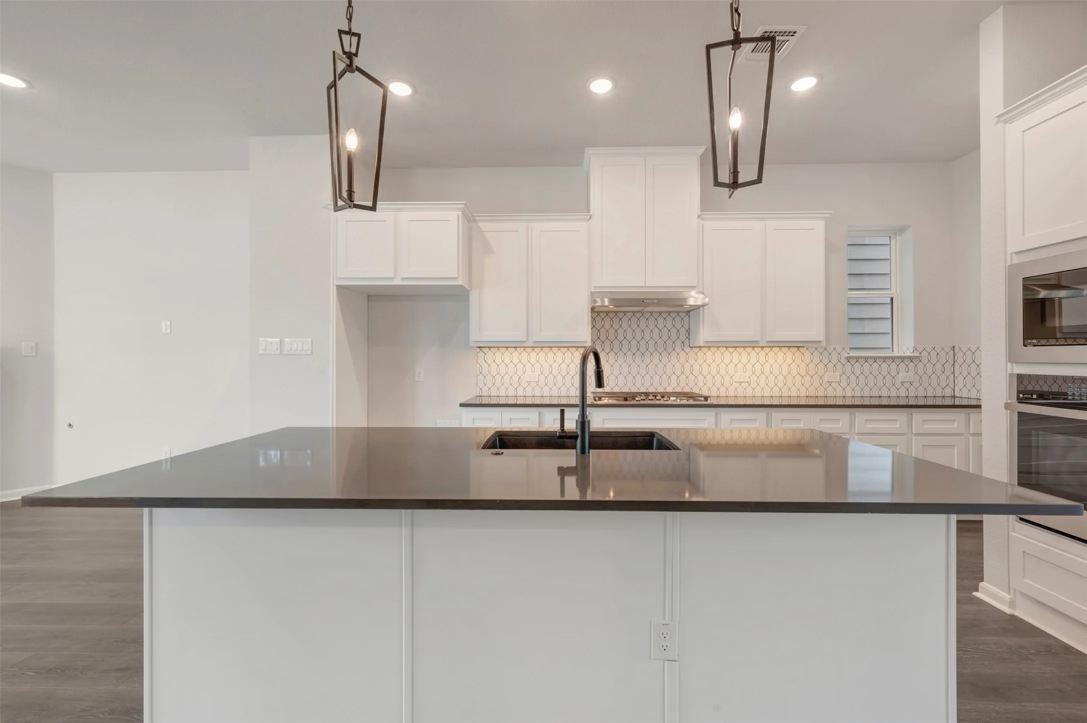 Spacious kitchen island featuring a dark countertop and integrated sink