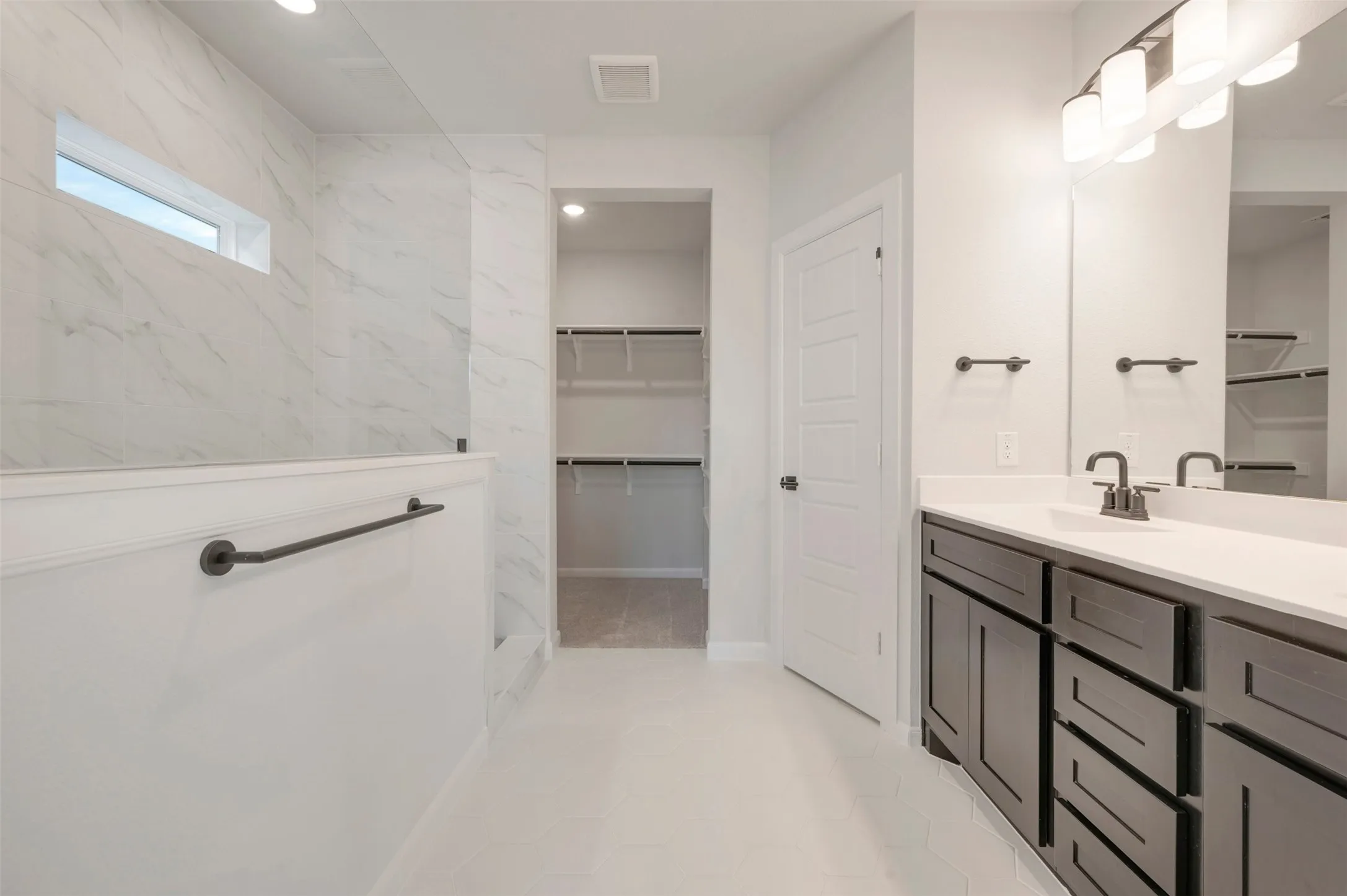 Bathroom vanity featuring a light-toned countertop, dark-finish cabinetry, and a contemporary faucet