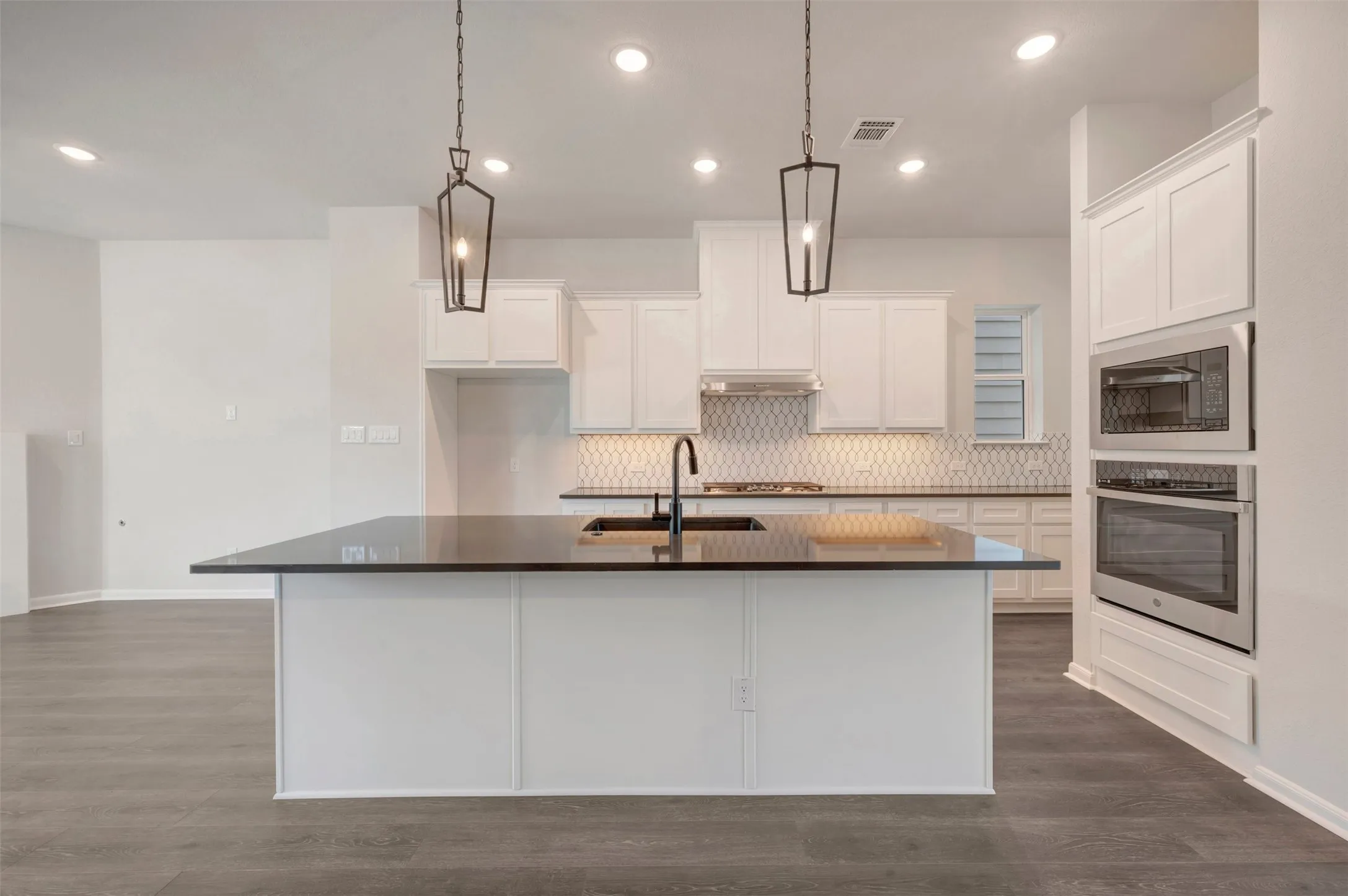 Kitchen island featuring a black countertop and integrated sink