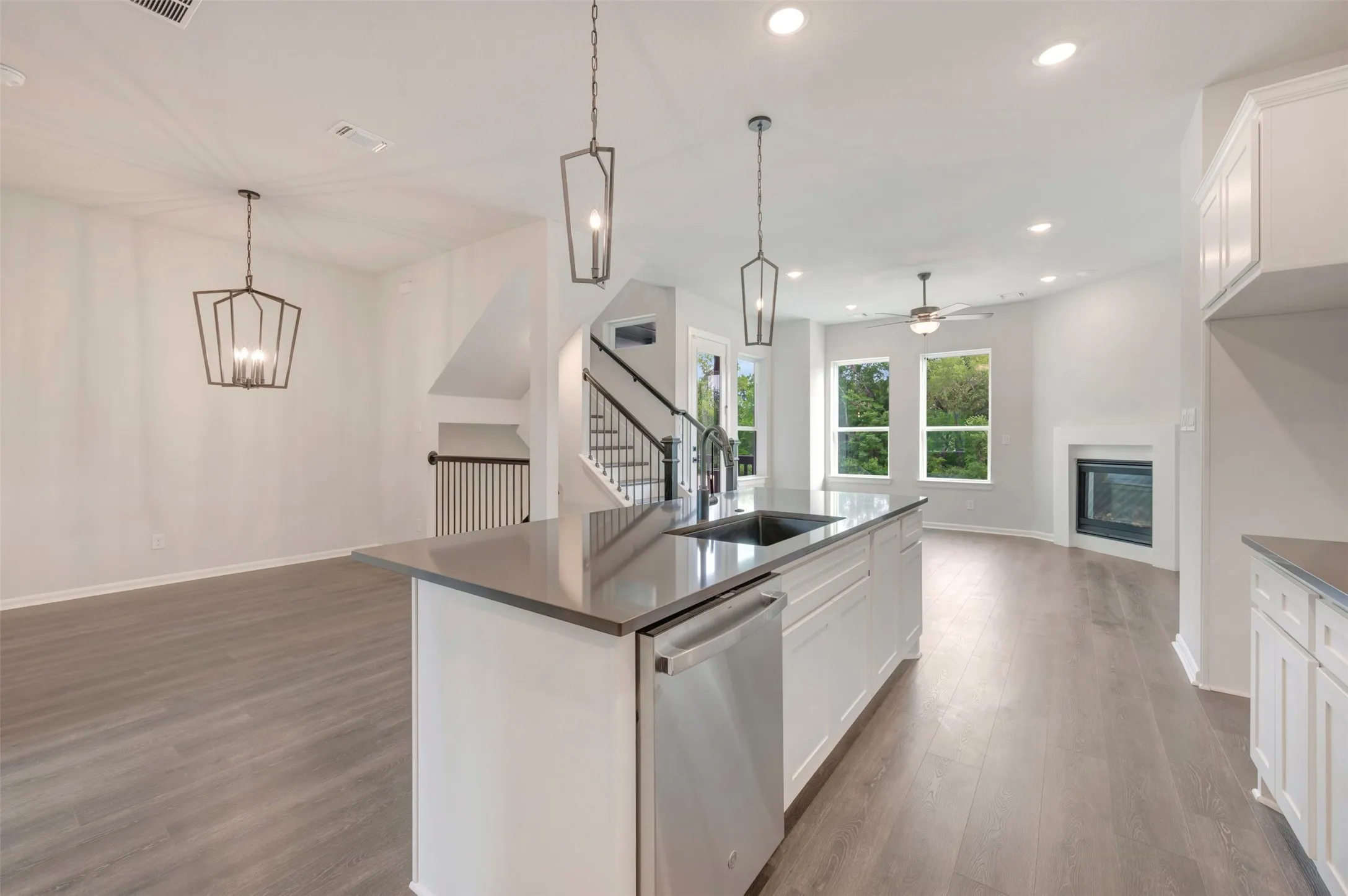 Kitchen island with an undermount sink, stainless steel dishwasher, and pendant lighting