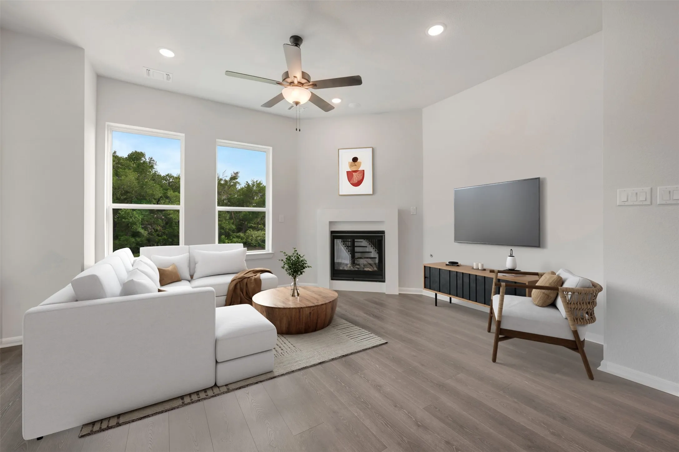 Spacious living area featuring wood-finish flooring, a contemporary fireplace, and recessed lighting