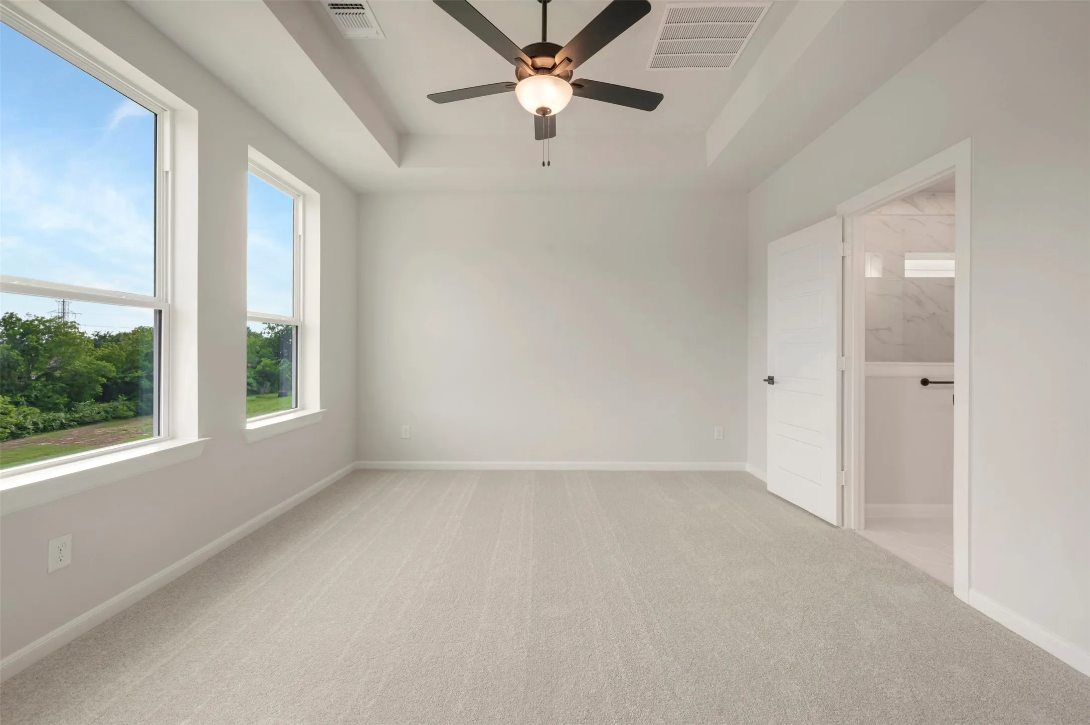 Neutral-toned wall-to-wall carpeting complements the light wall color