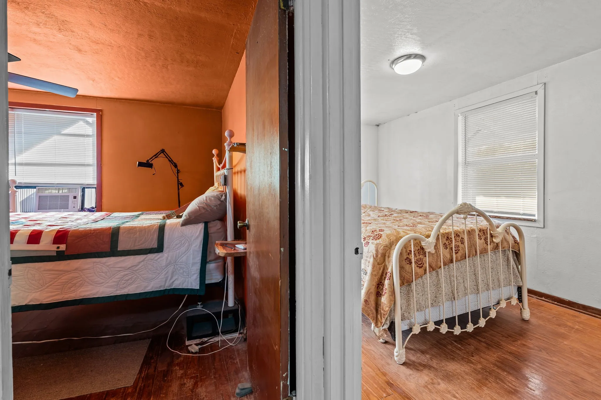 Bedroom with wood finished floors, a textured ceiling, and cooling unit