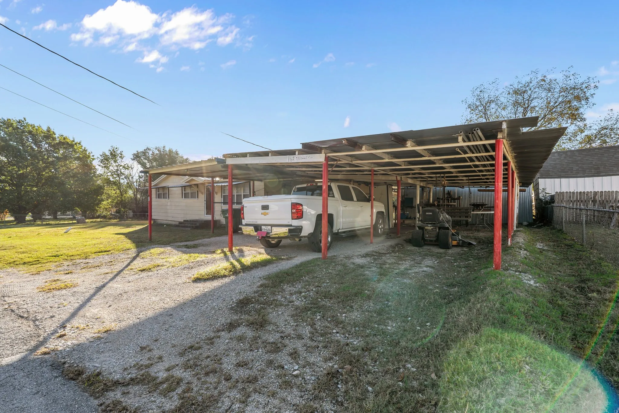 View of vehicle parking with driveway and a carport