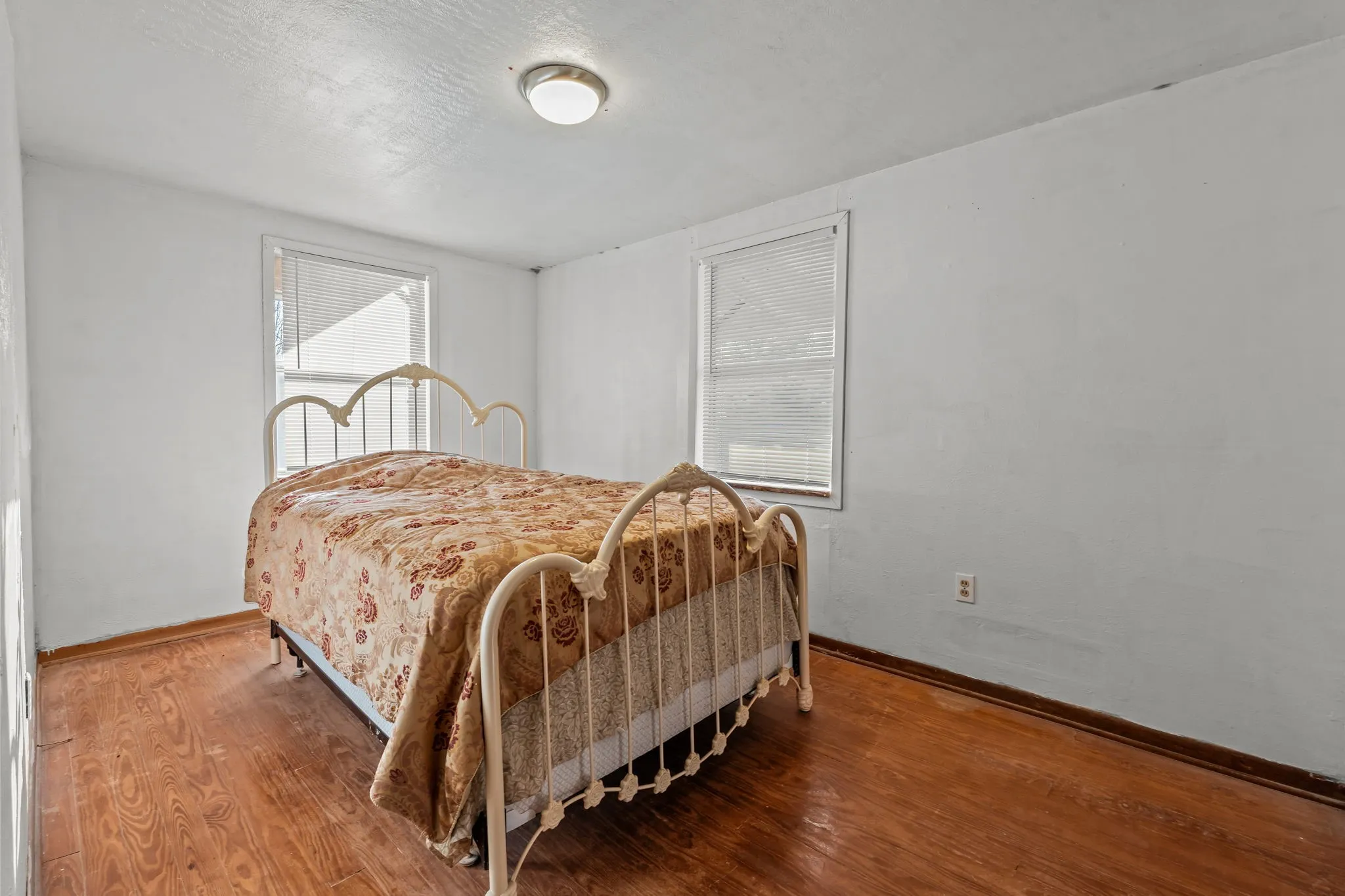 Bedroom with wood finished floors and a textured ceiling