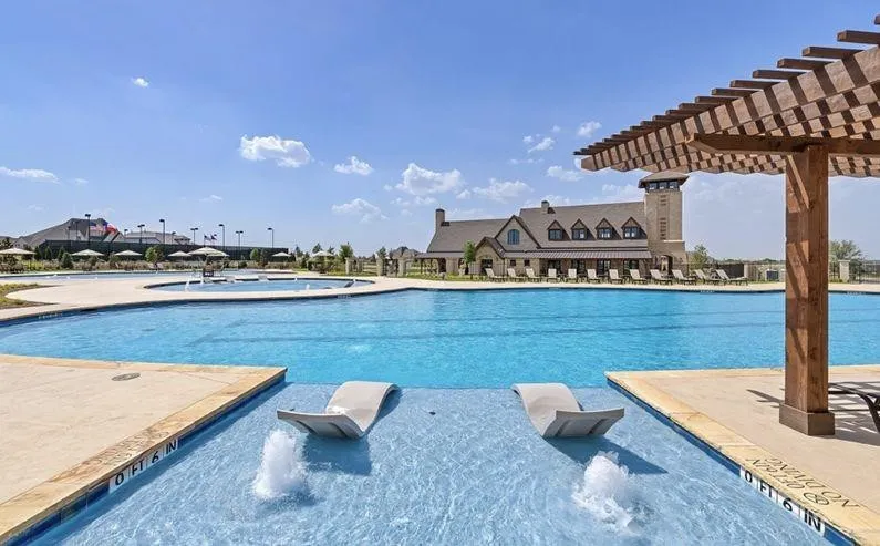 Community pool featuring a pergola and a patio