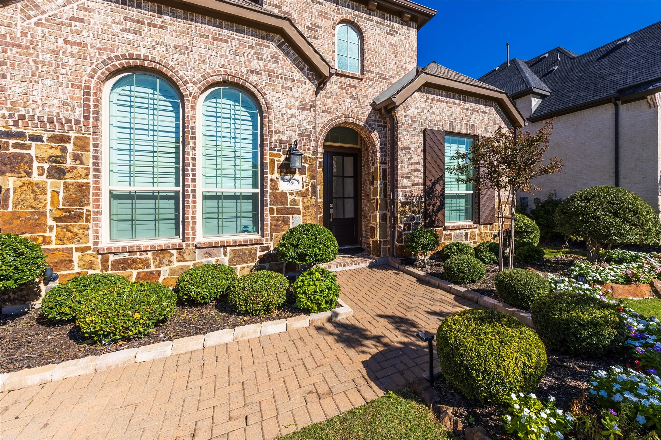 View of exterior entry with brick siding and stone siding