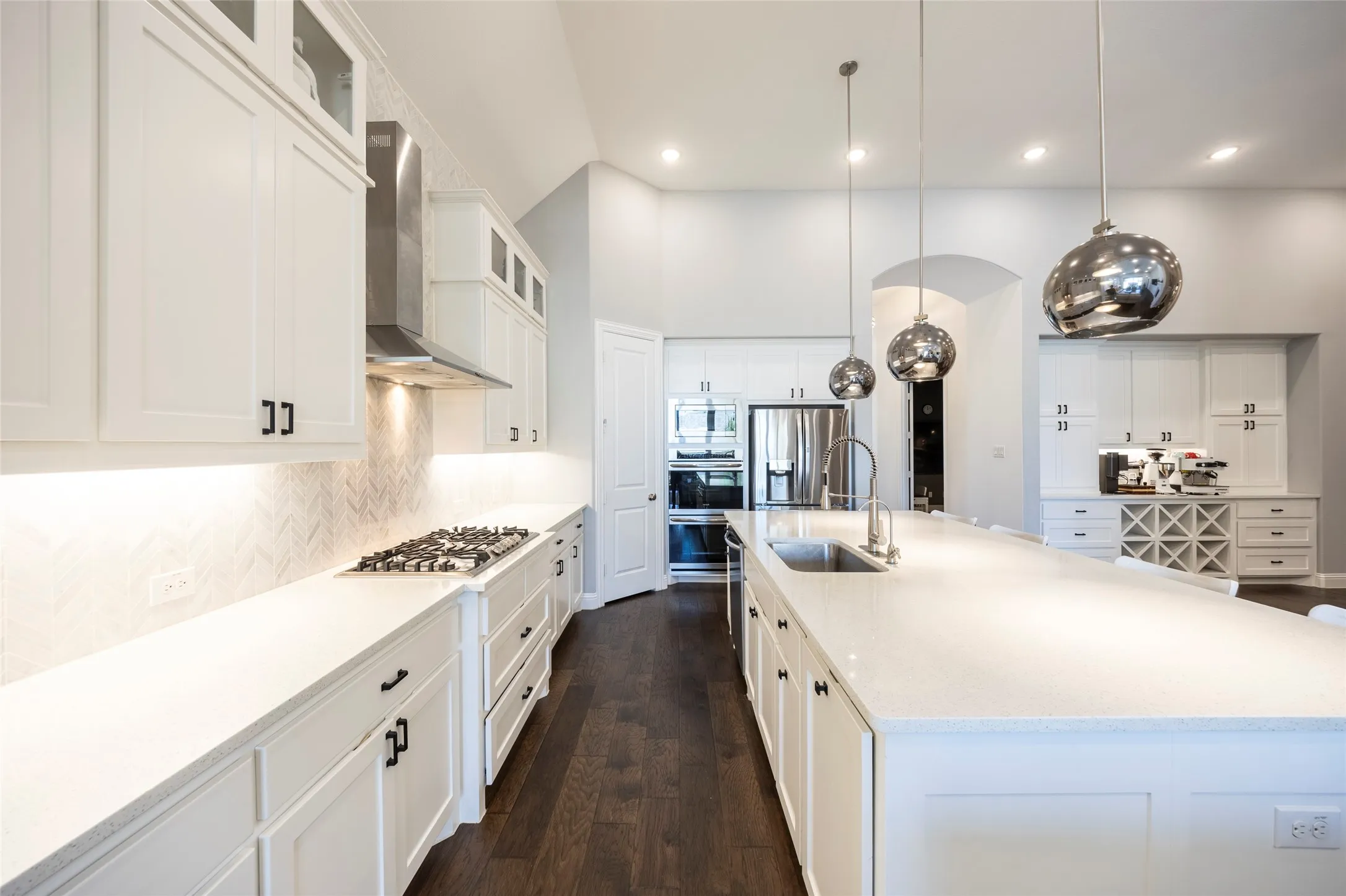Kitchen featuring white cabinetry, glass insert cabinets, dark wood-type flooring, tasteful backsplash, and recessed lighting