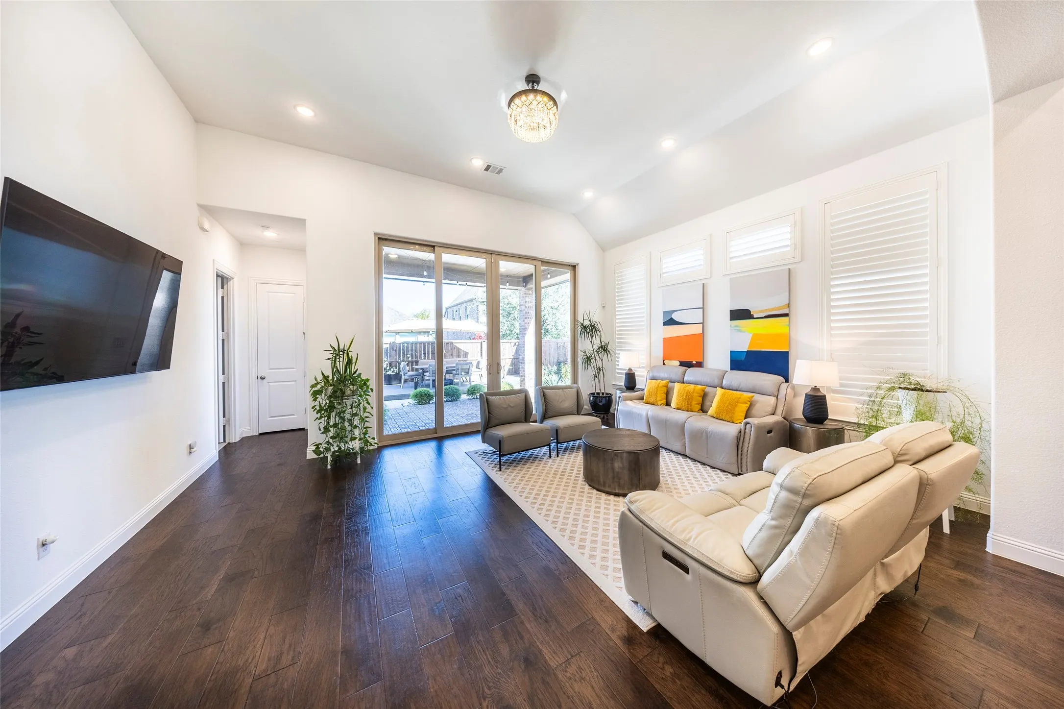 Living room featuring dark wood finished floors, recessed lighting, lofted ceiling, and french doors