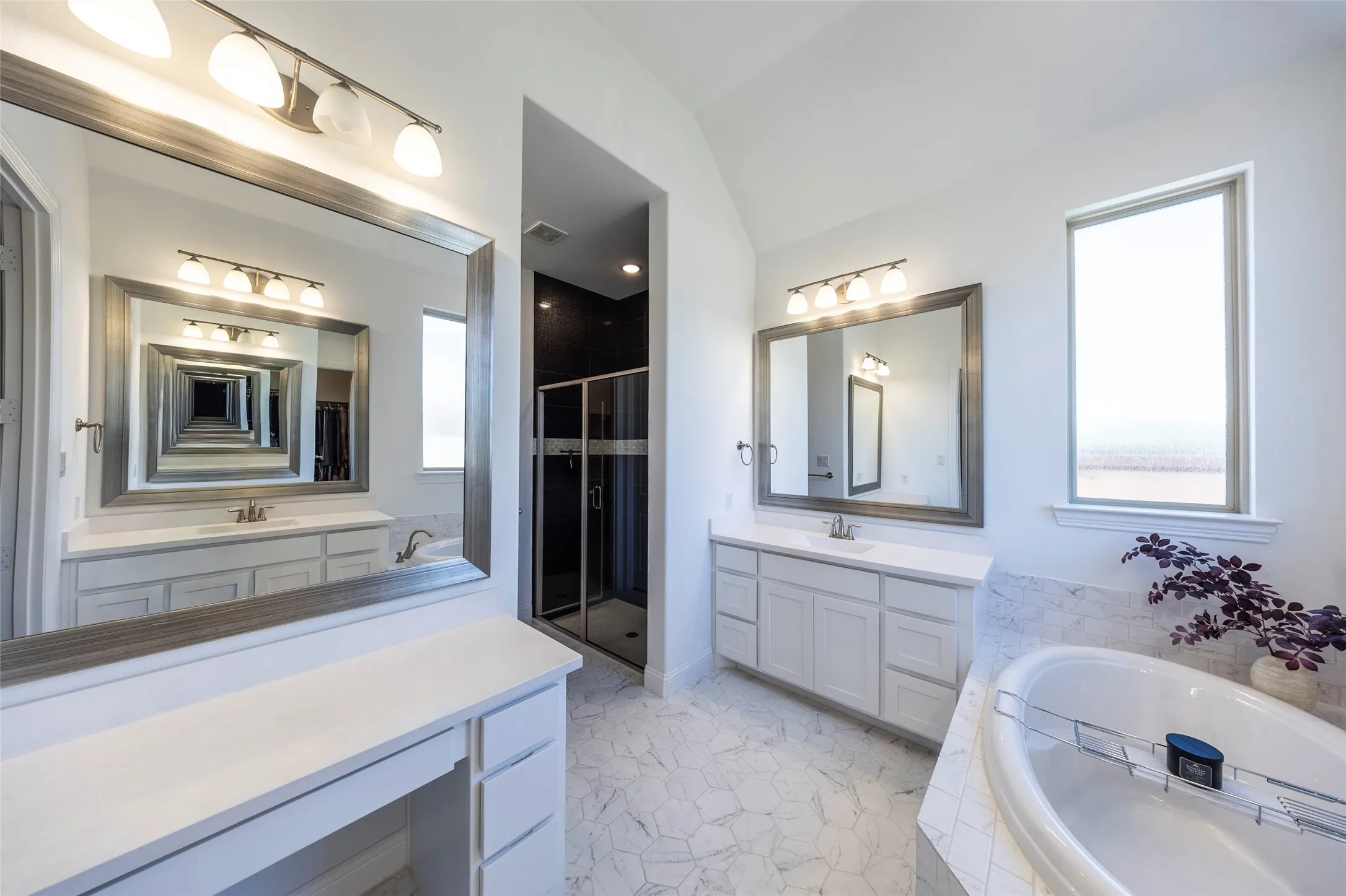 Full bathroom with a bath, two vanities, a stall shower, and lofted ceiling