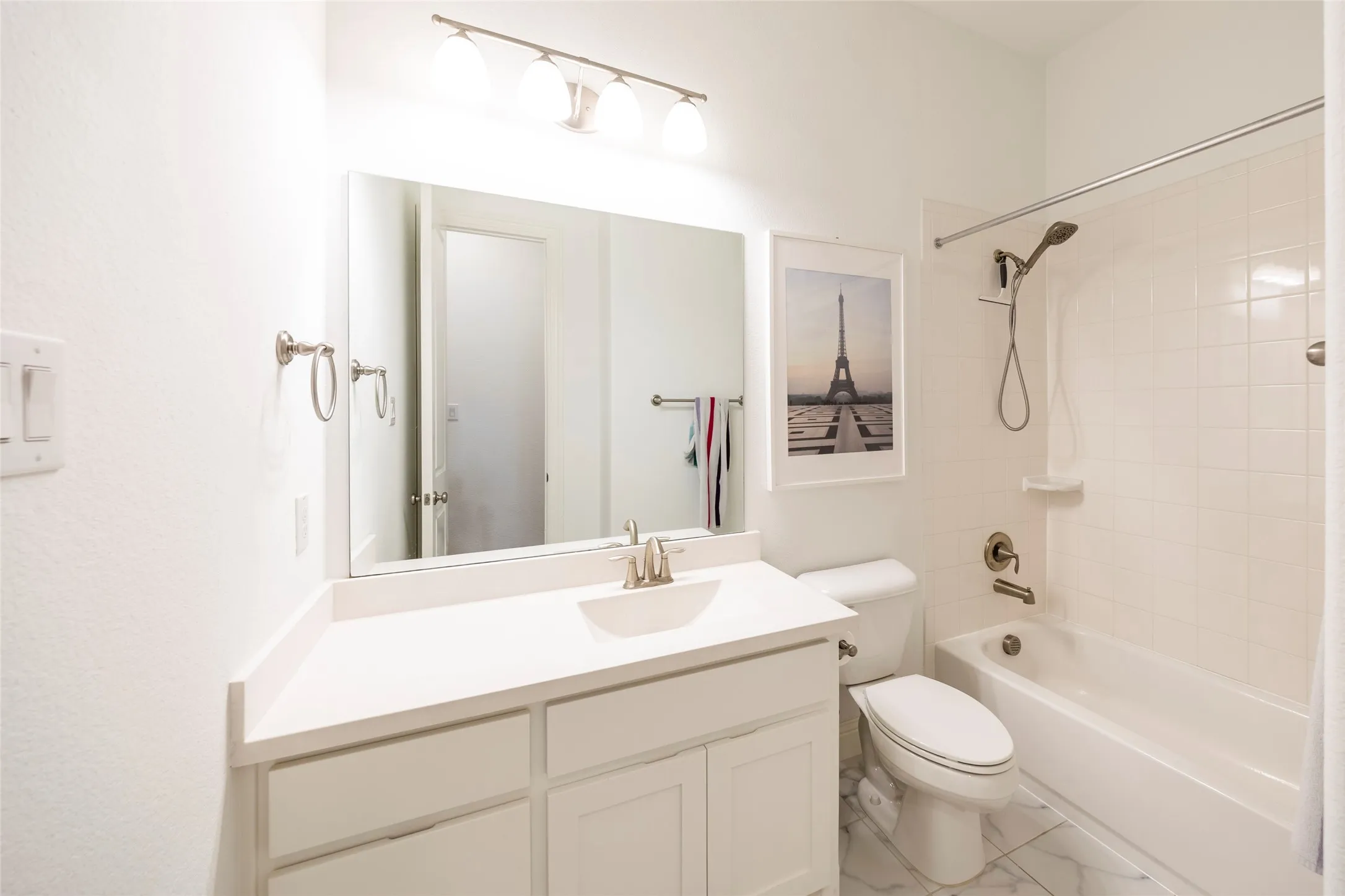 Full bathroom with shower / tub combination, vanity, and light marble finish floors