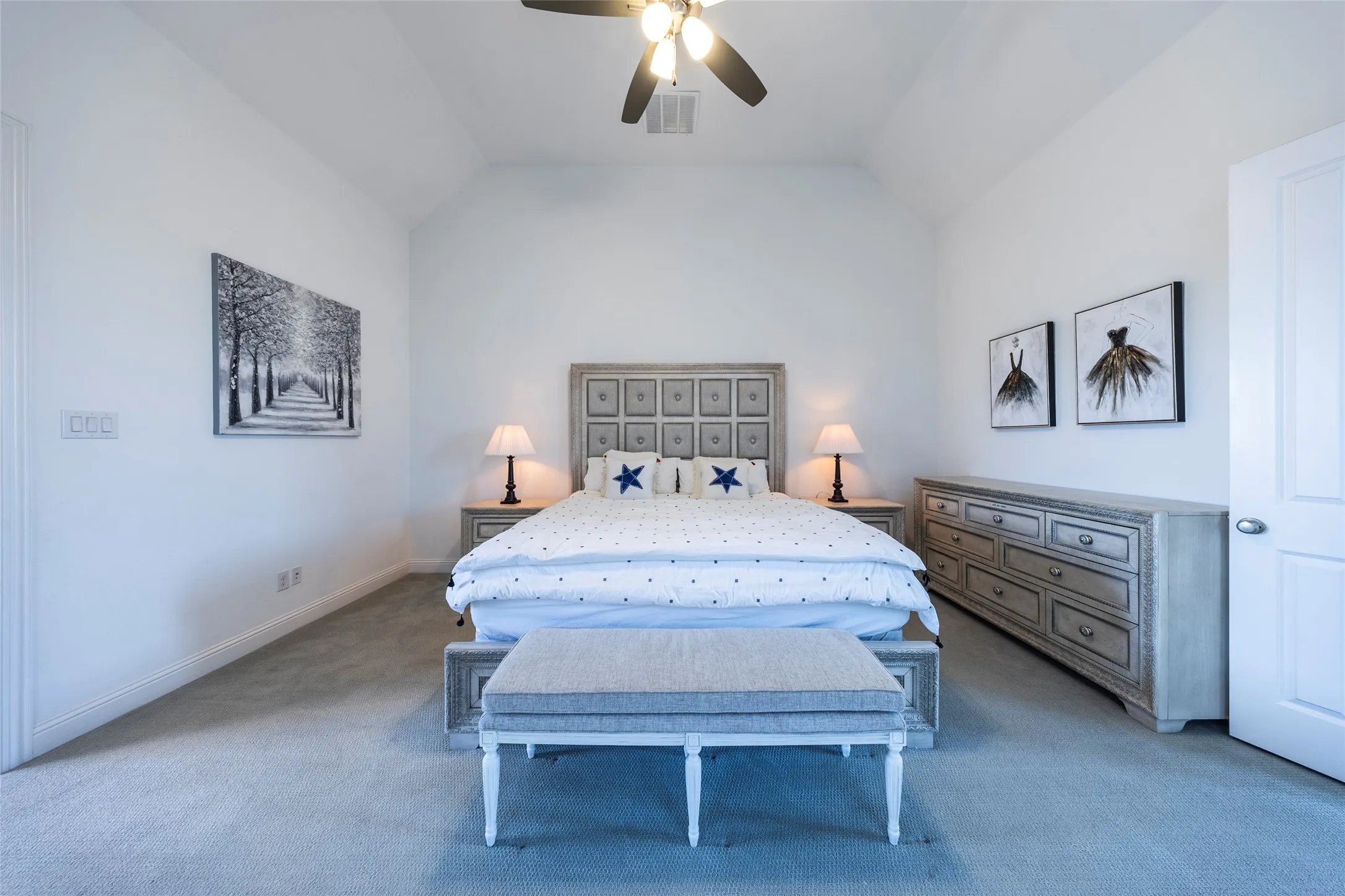 Carpeted bedroom featuring vaulted ceiling and a ceiling fan