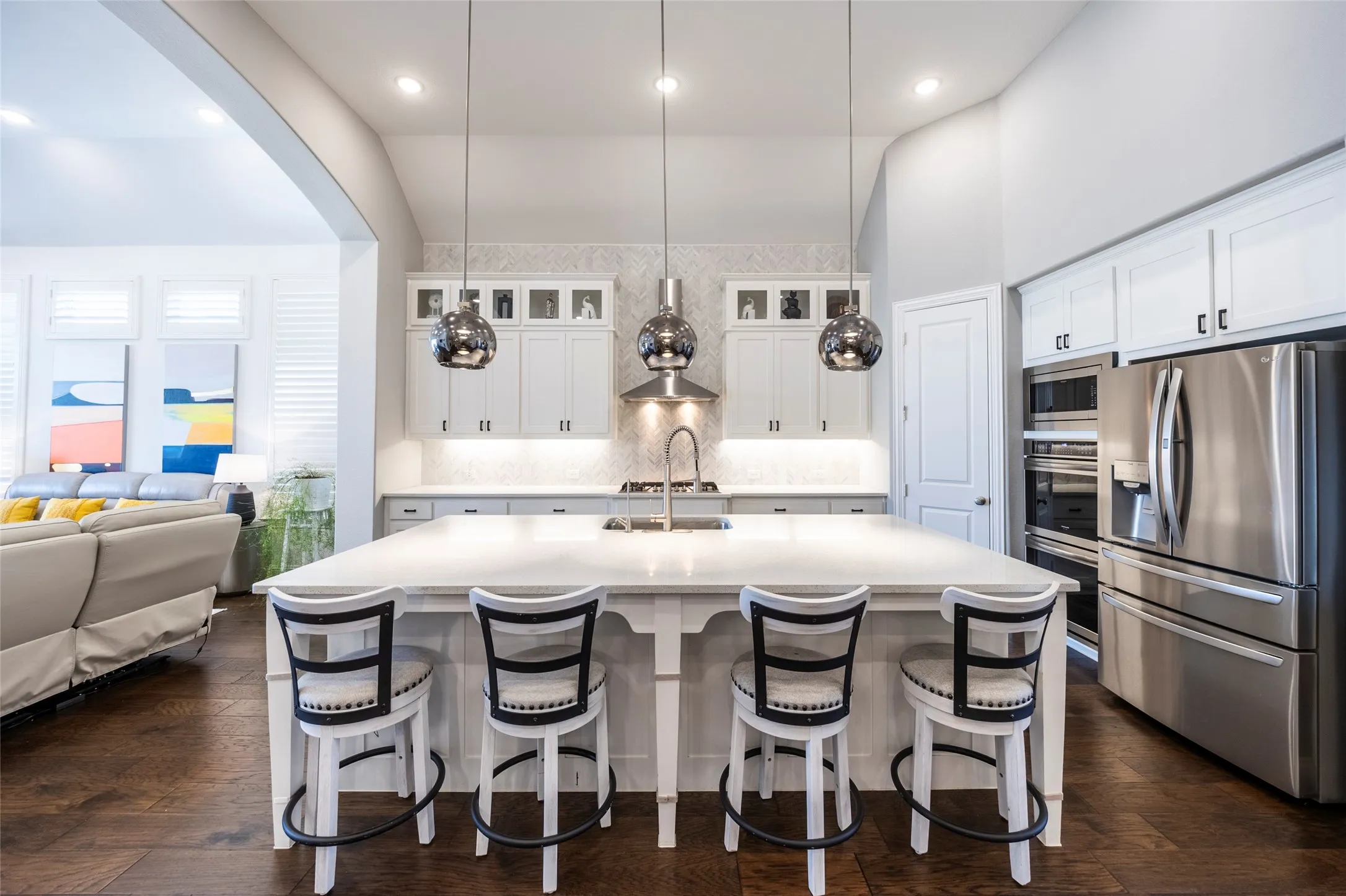 Kitchen with stainless steel appliances, white cabinets, pendant lighting, decorative backsplash, and recessed lighting