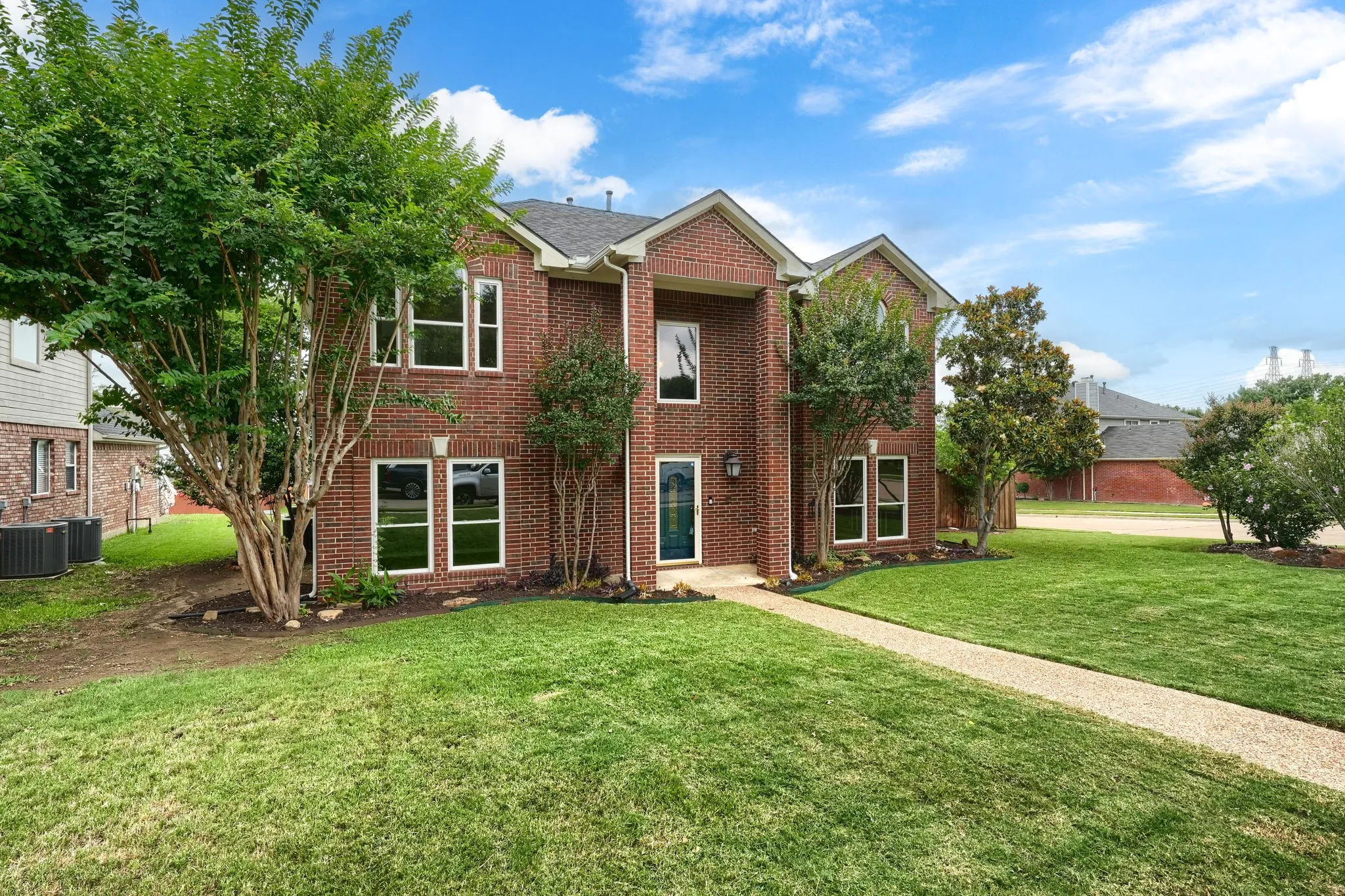 Brick two-story exterior featuring multiple gables and white-trimmed windows